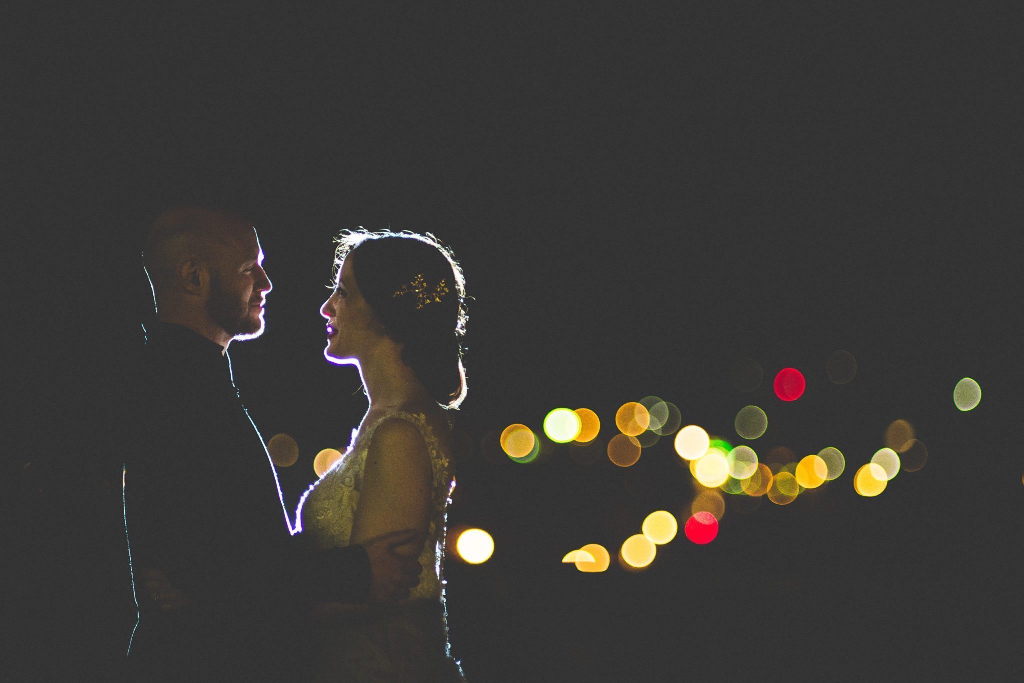 Backlit bride and groom smiling at each other at their Scottish Farnham Castle wedding