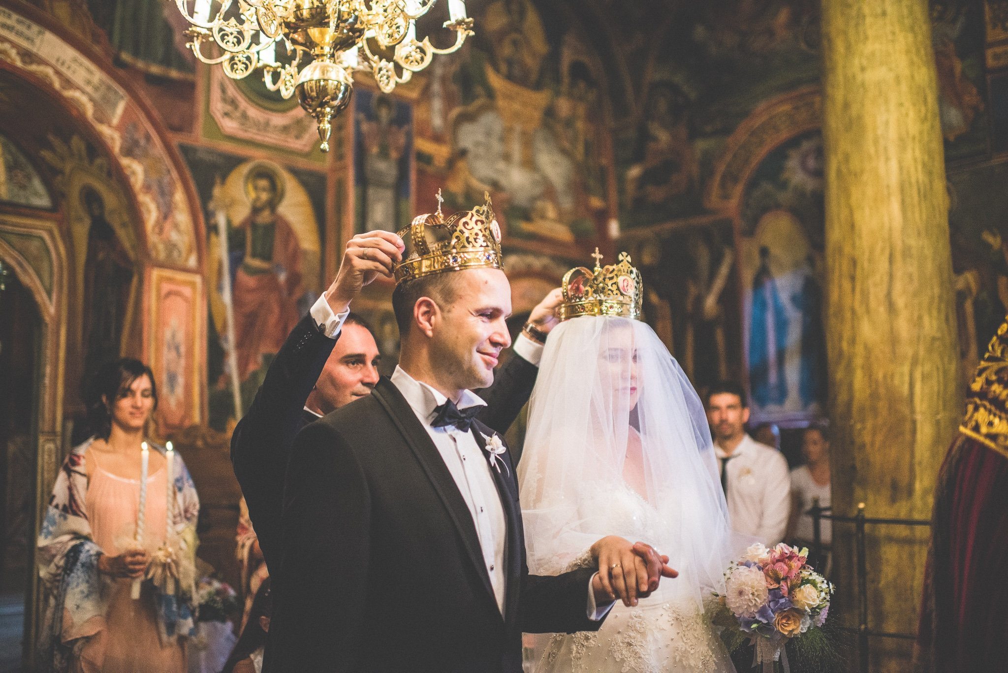 Ornate gold crowns are placed on the couple's heads during their Orthodox wedding ceremony