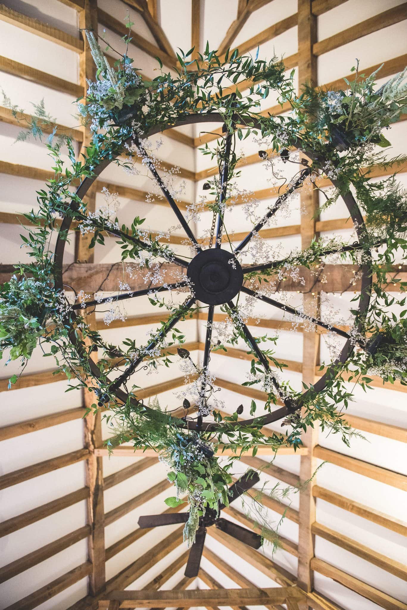 A foliage chandelier hanging in the rafters of a Gate Street Barn Wedding