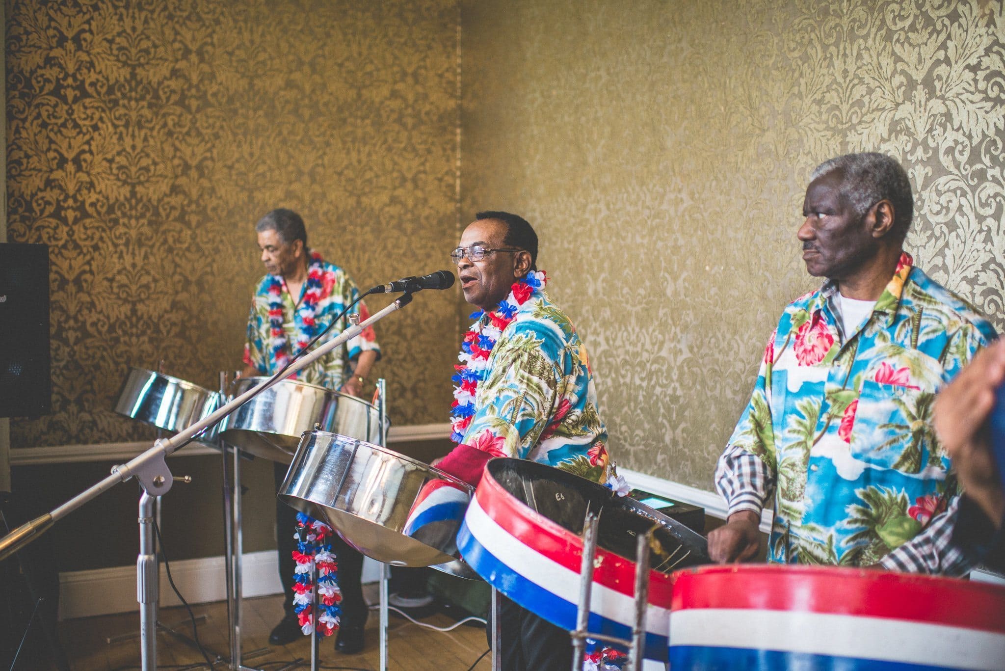 A steel band plays, wearing Hawaiian shirts and red, white and blue flower garlands 