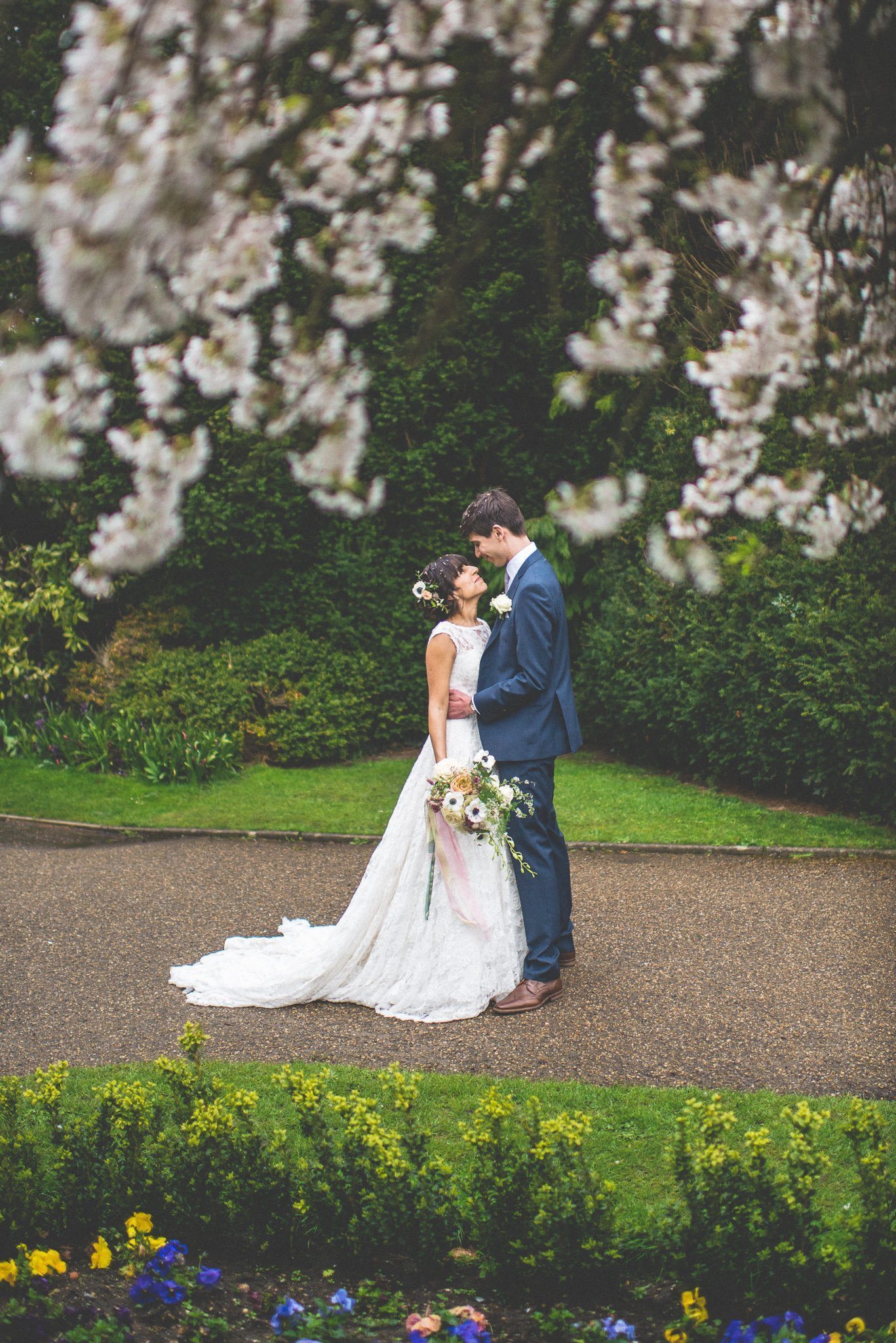 Bride and Groom standing among spring blossom at Nonsuch Mansion