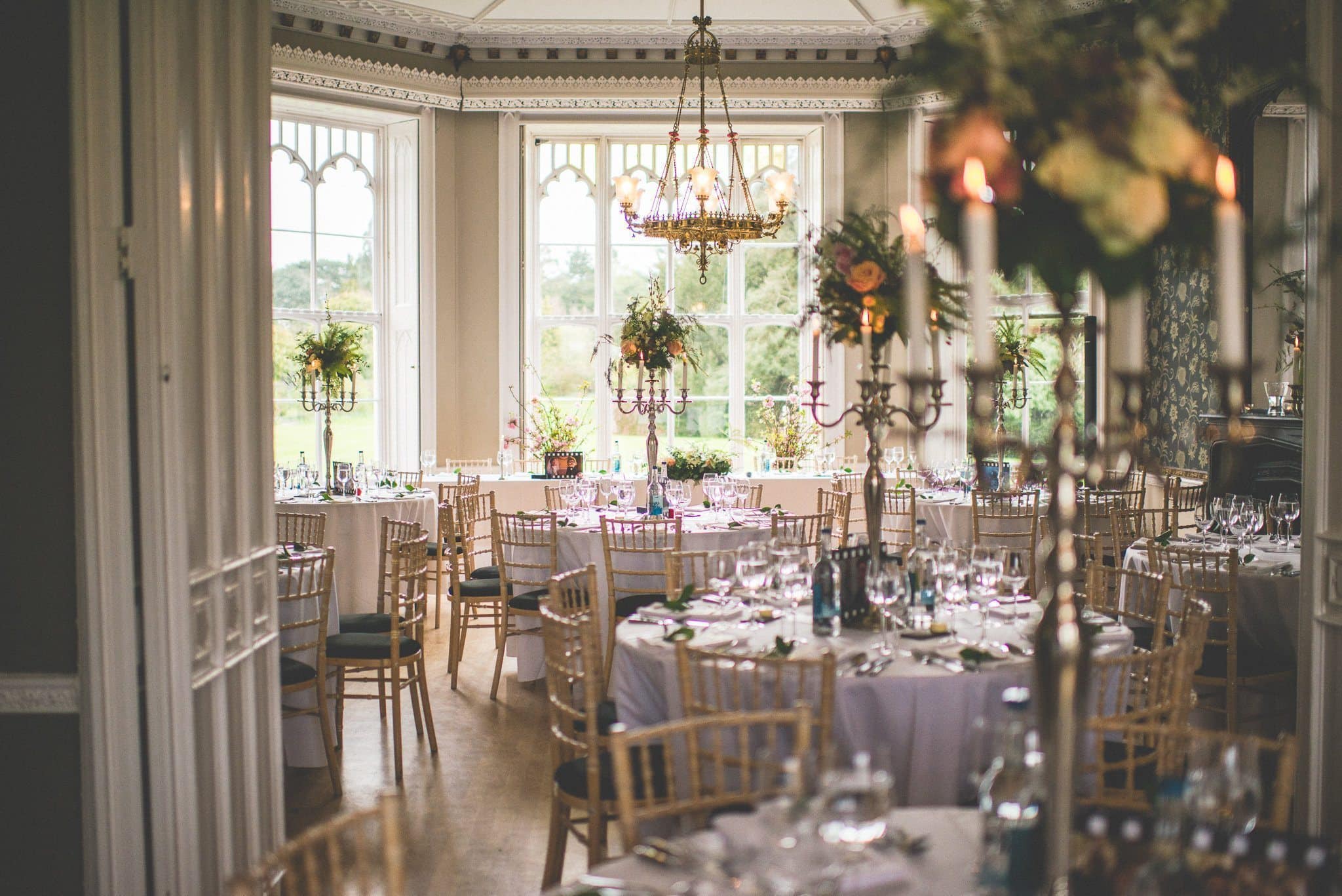 Nonsuch Mansion reception room decorated with candelabras & tall floral arrangements