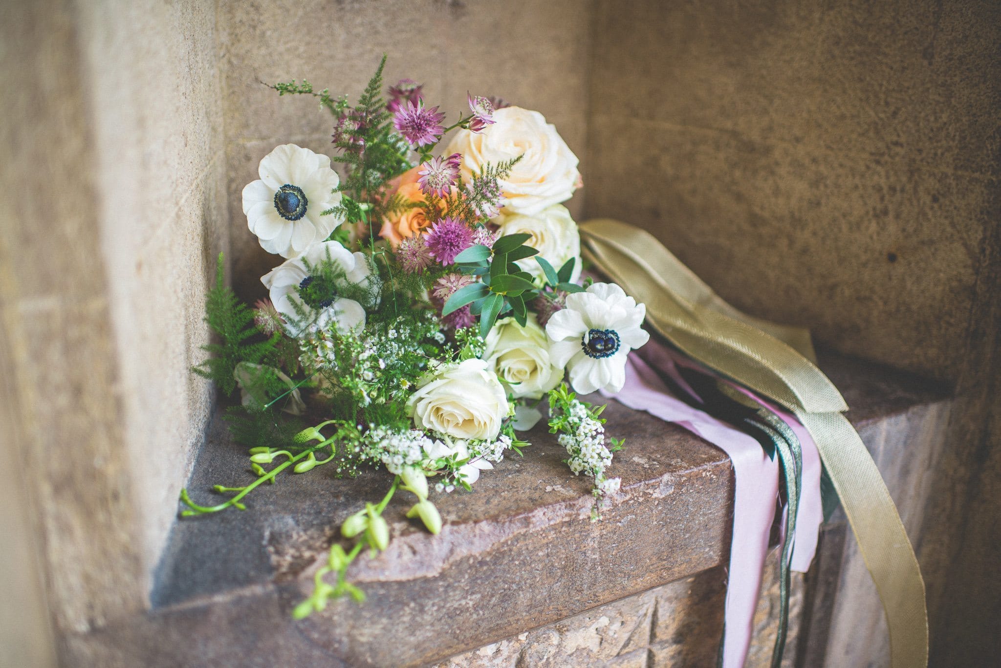 Jasmin's bridal bouquet - featuring anemones and cream and orange roses, and tied with colourful silk ribbon