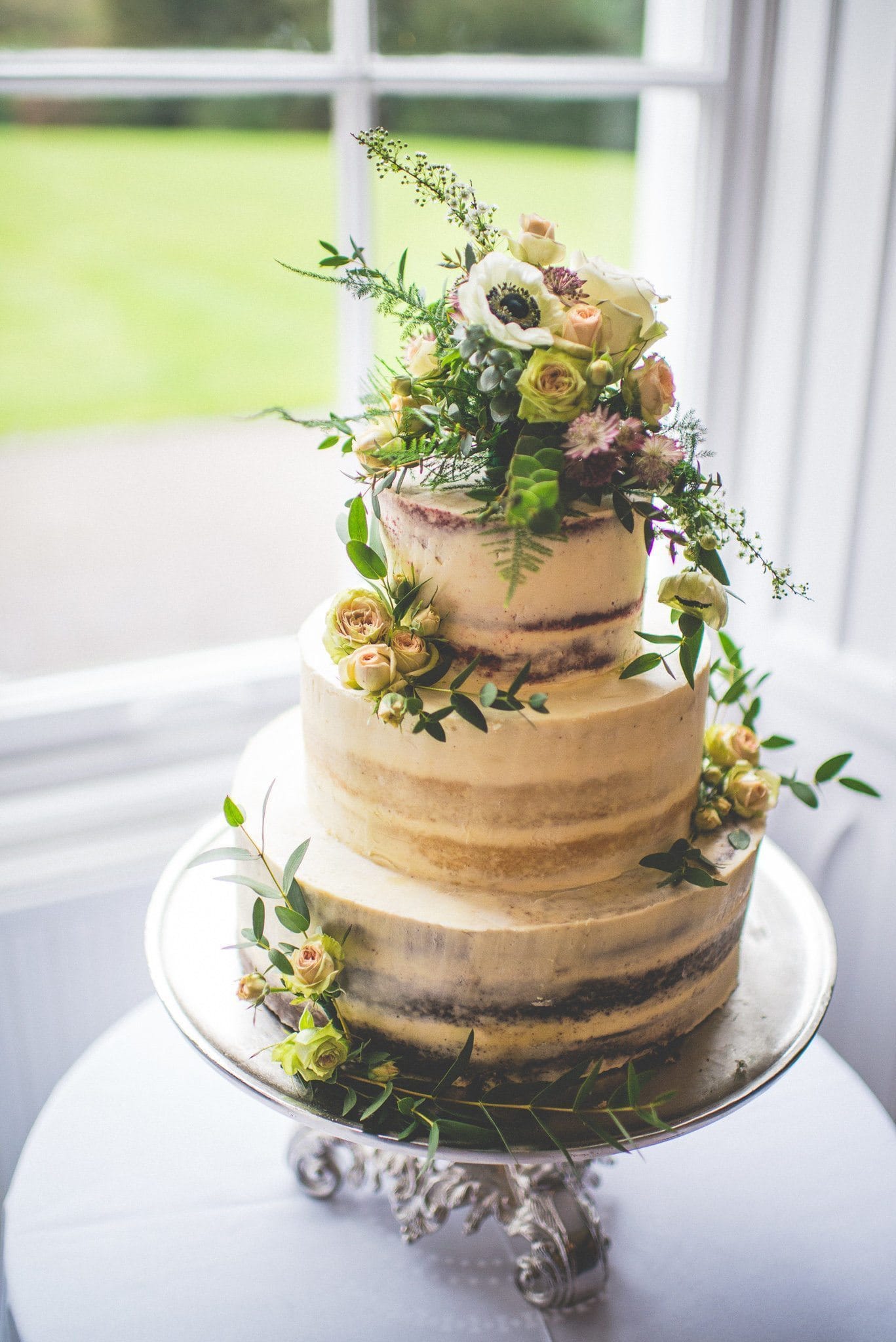 The semi-naked cake, with different flavoured sponge on each tier. It is decorated with beautiful fresh flowers.