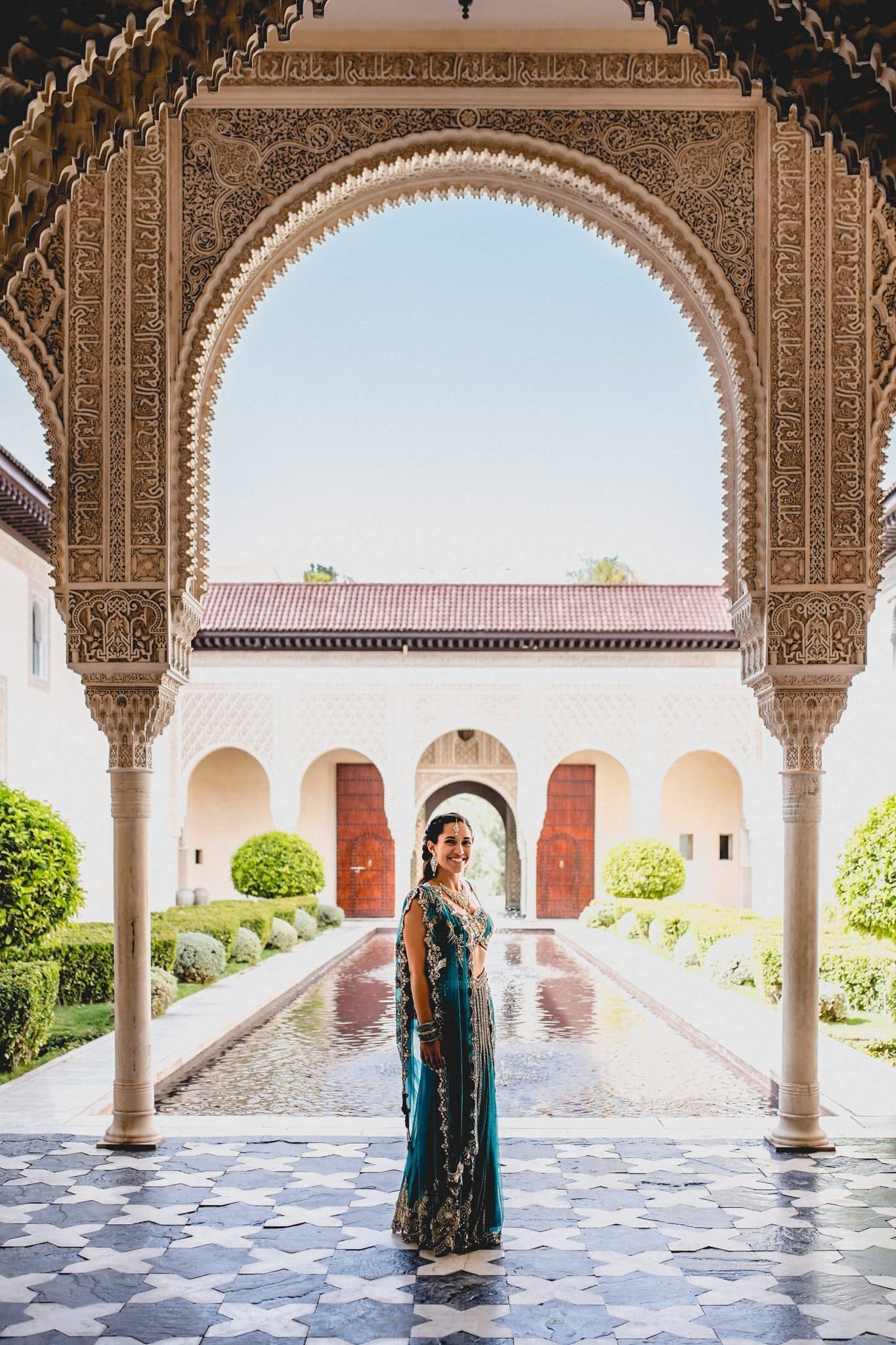 Indian bride standing under the Moroccan arches at Ksar Char Bagh in Marrakech