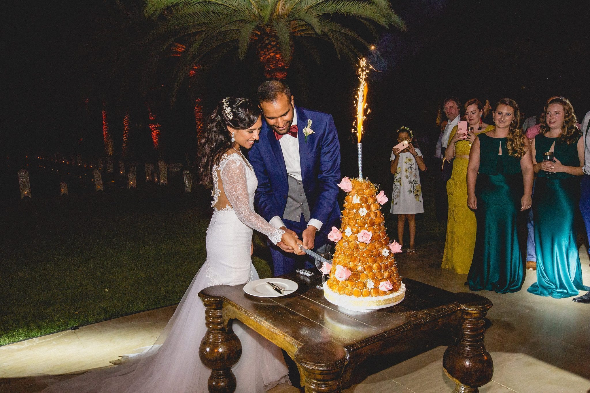 The couple cut their croque en bouche cake outside