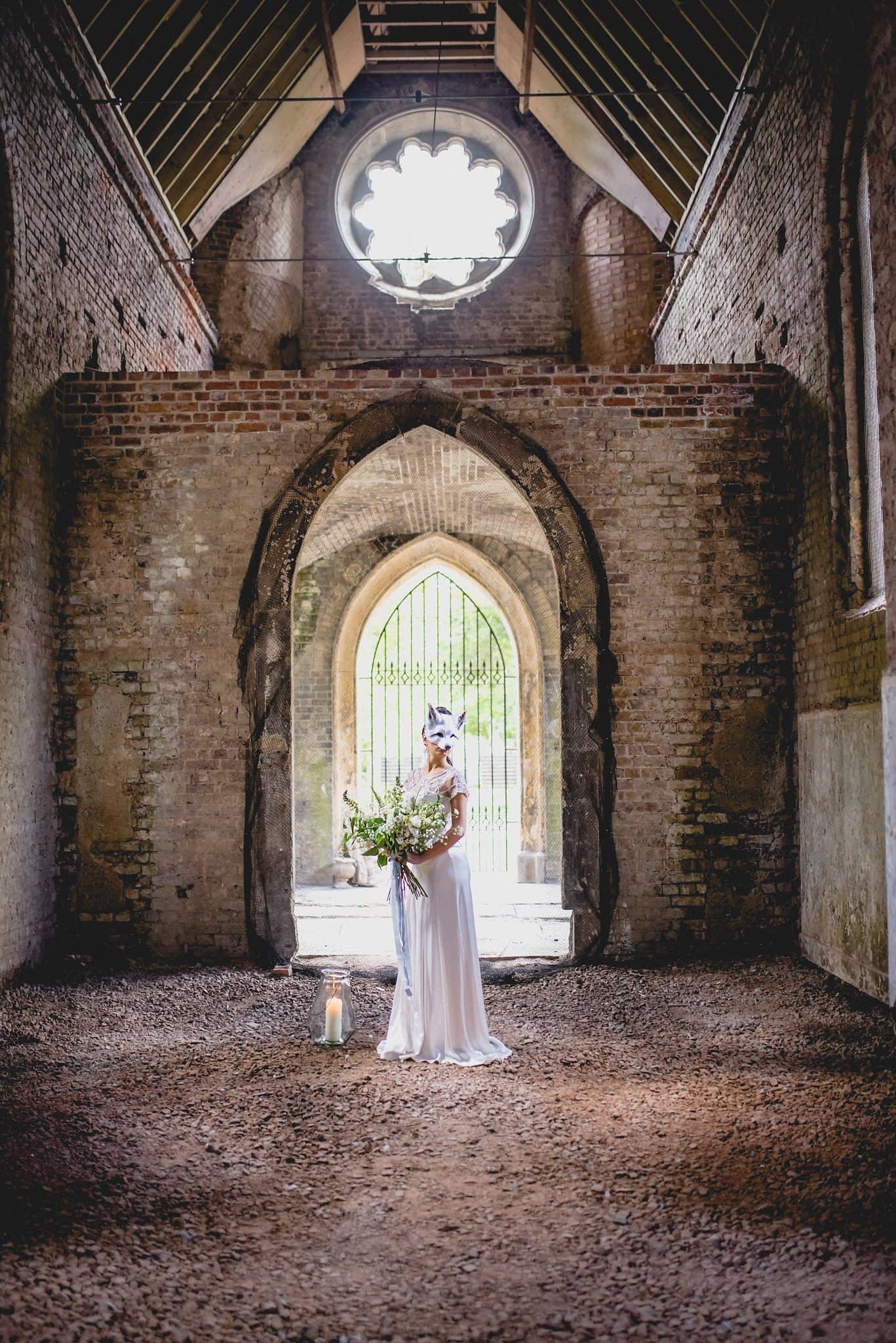 Bride in Catherine Deane standing in the ruined Gothic chapel at Abney Park cemetery