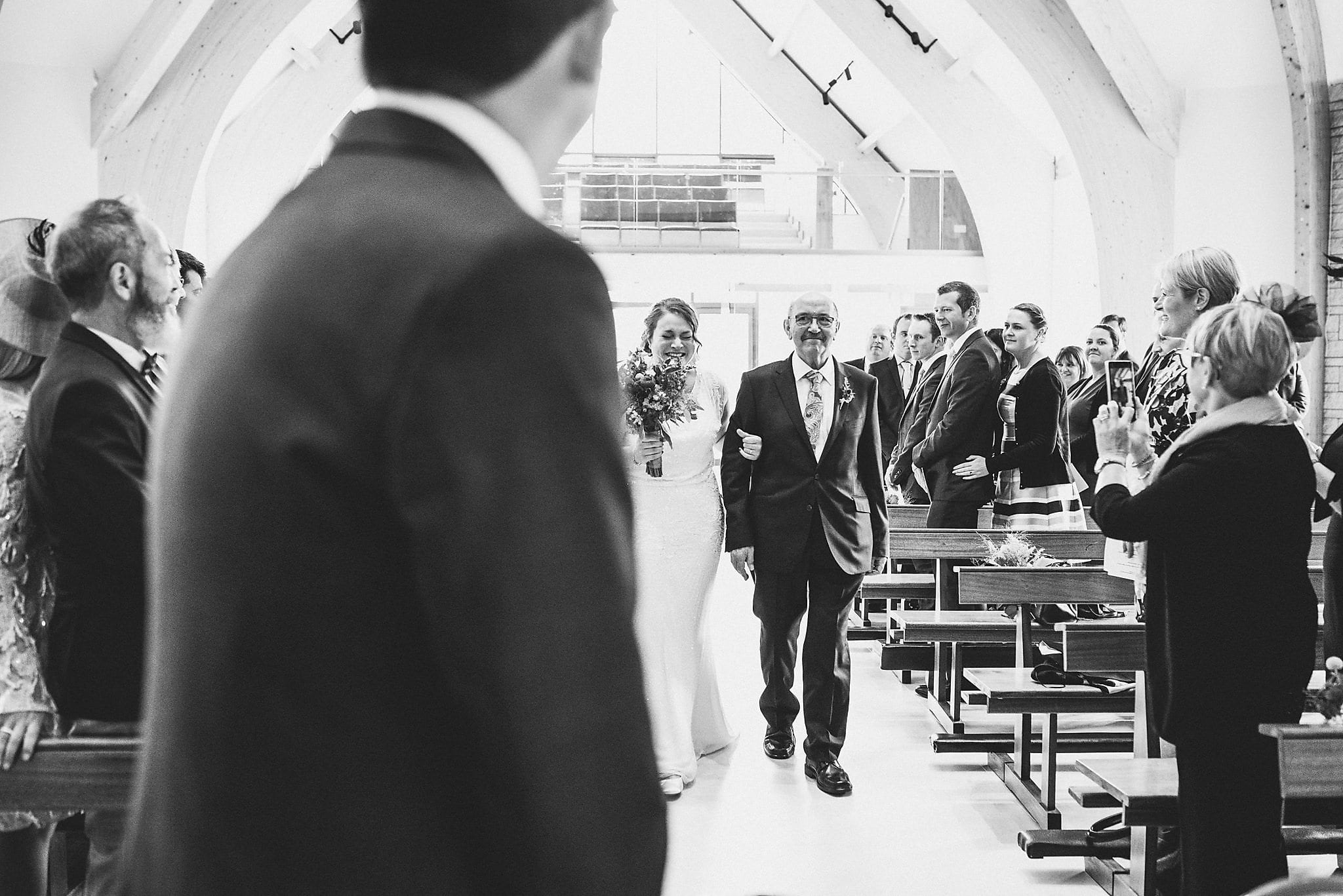 Bride walking down the aisle and laughing with happiness