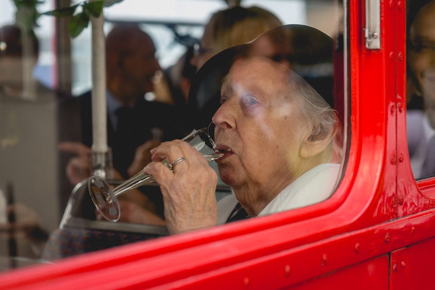 Bride's grandmother sips champagne on the bus on the way to the West Reservoir Wedding reception