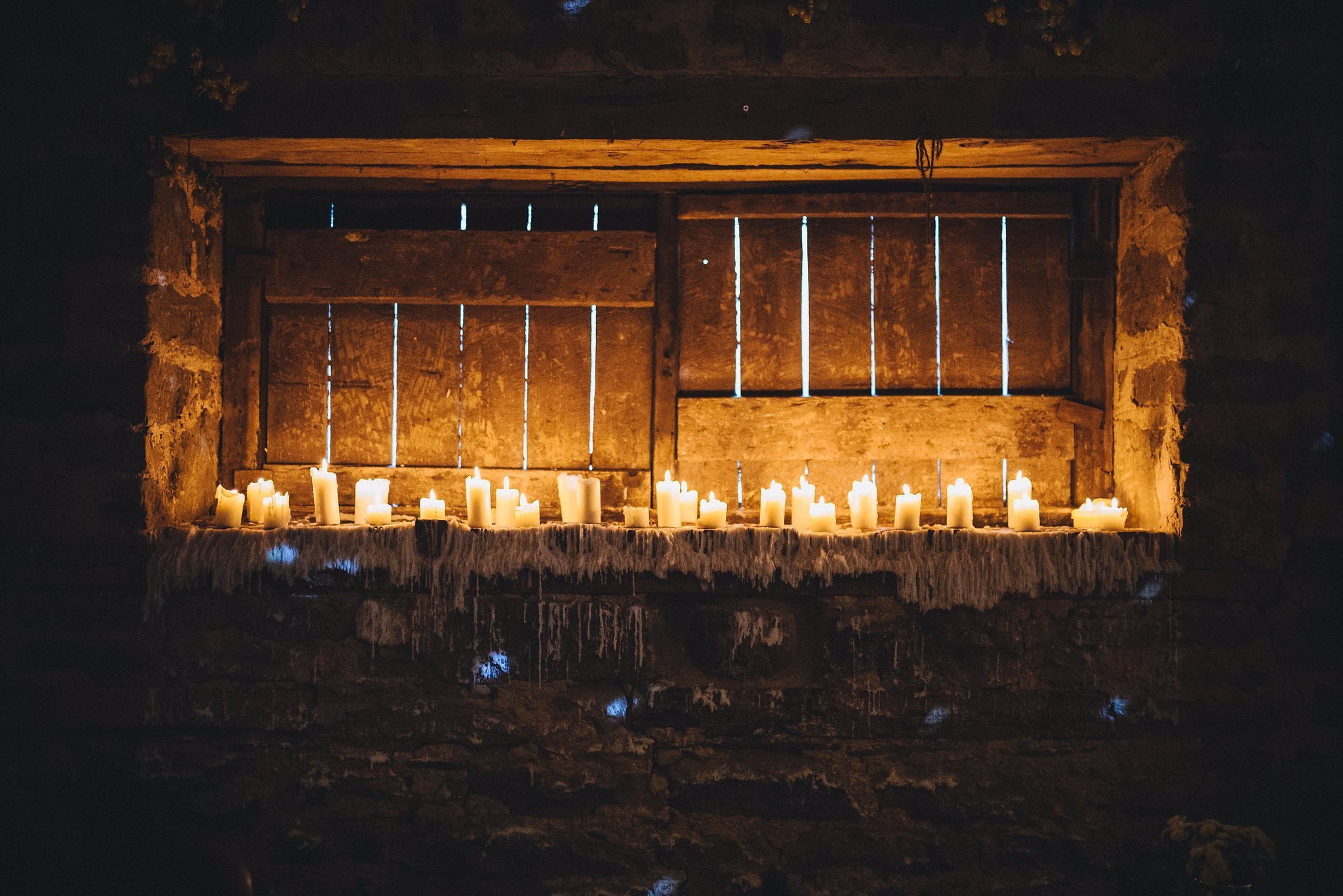 Row of candles on a window ledge with wax dripping down