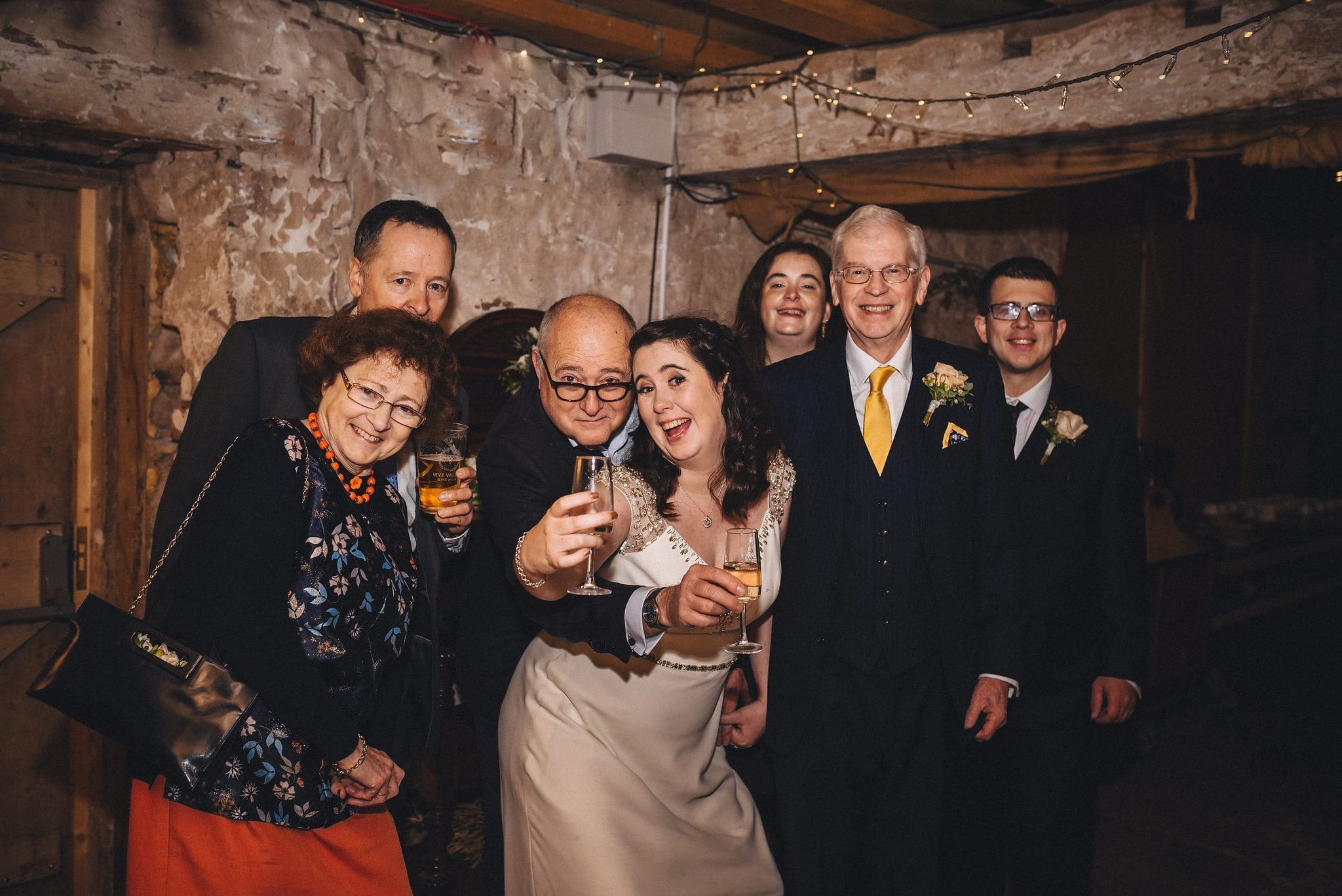 Bride poses with her family holding glasses of champagne