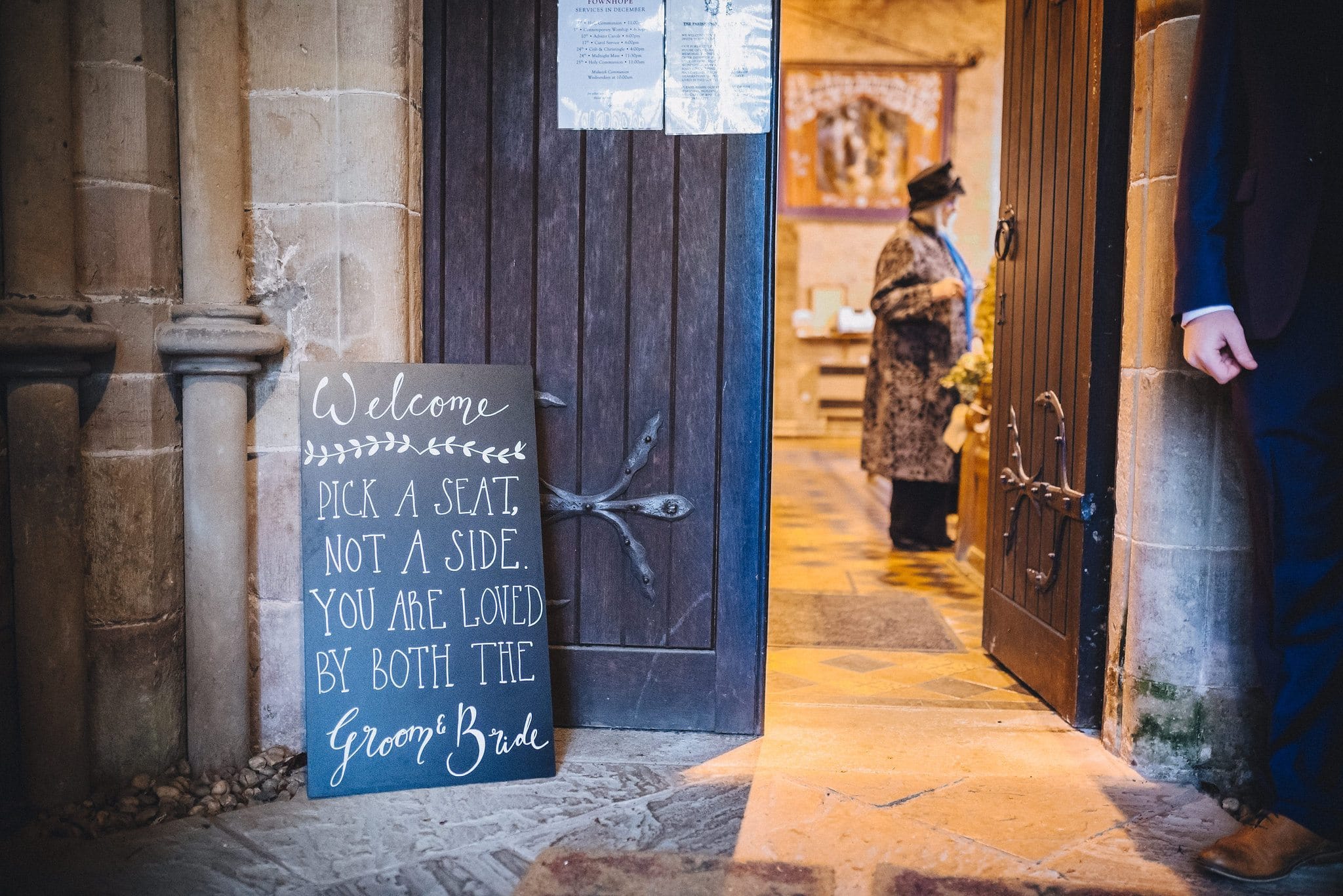 Chalkboard at church entrance 'Pick a seat, not a side - you are loved by both the groom & bride'