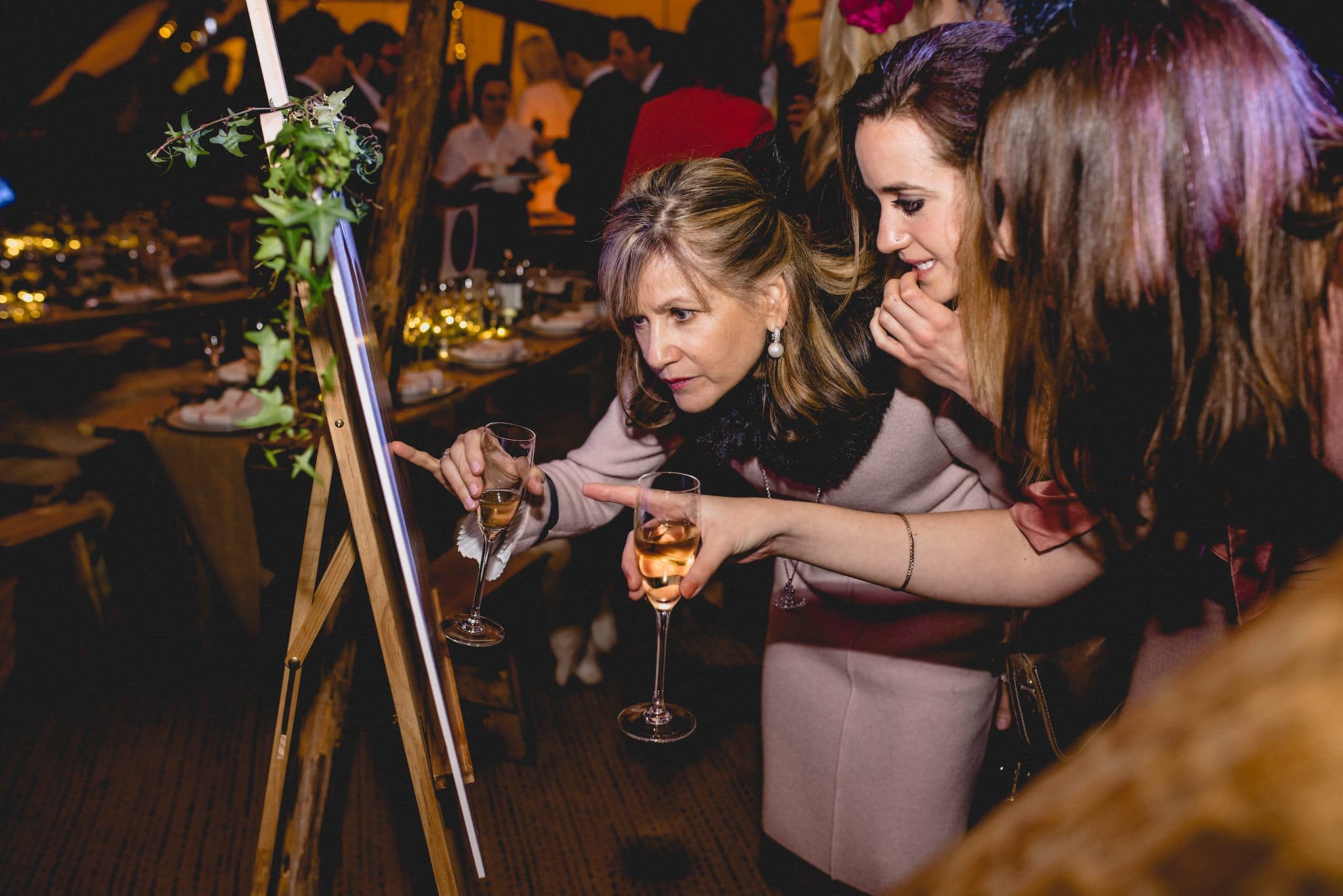 Guests search for their names on the table plan in the tipi