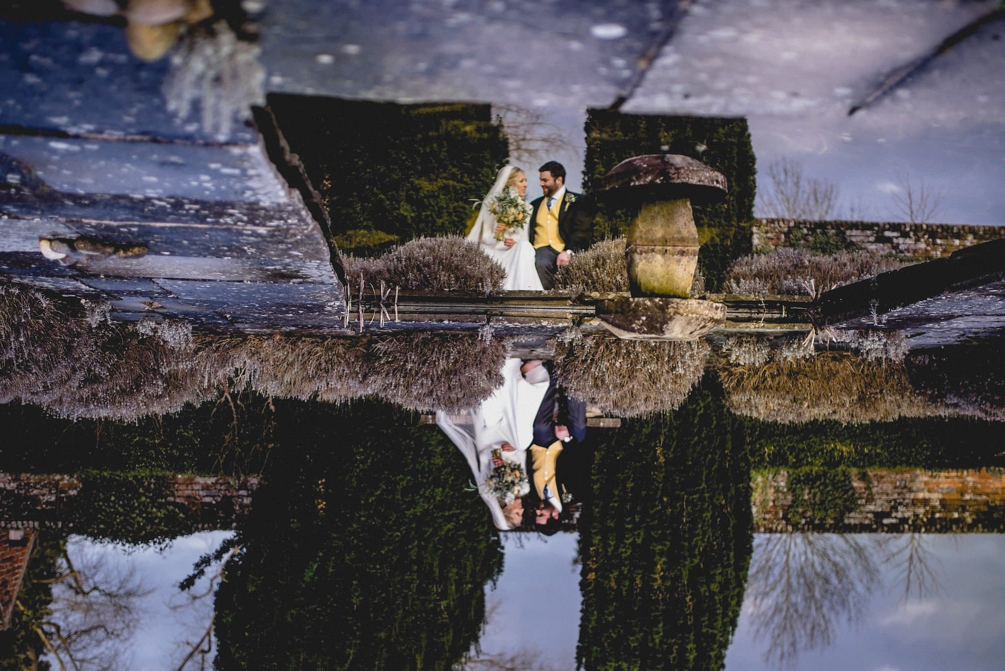 Couple's portrait and reflection in a pond at Littlefield Manor