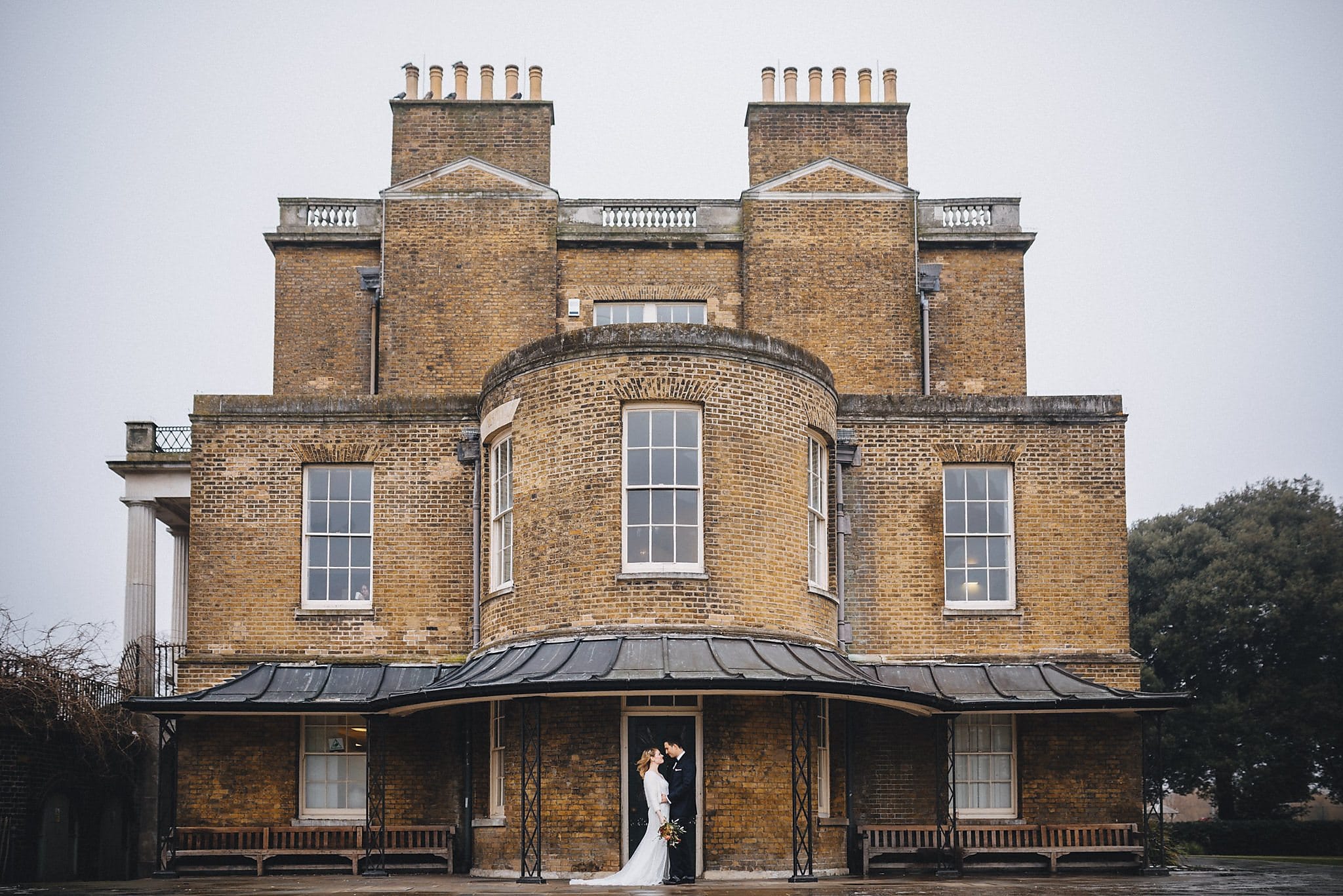 Bride and groom standing in front of Clissold House for their wedding