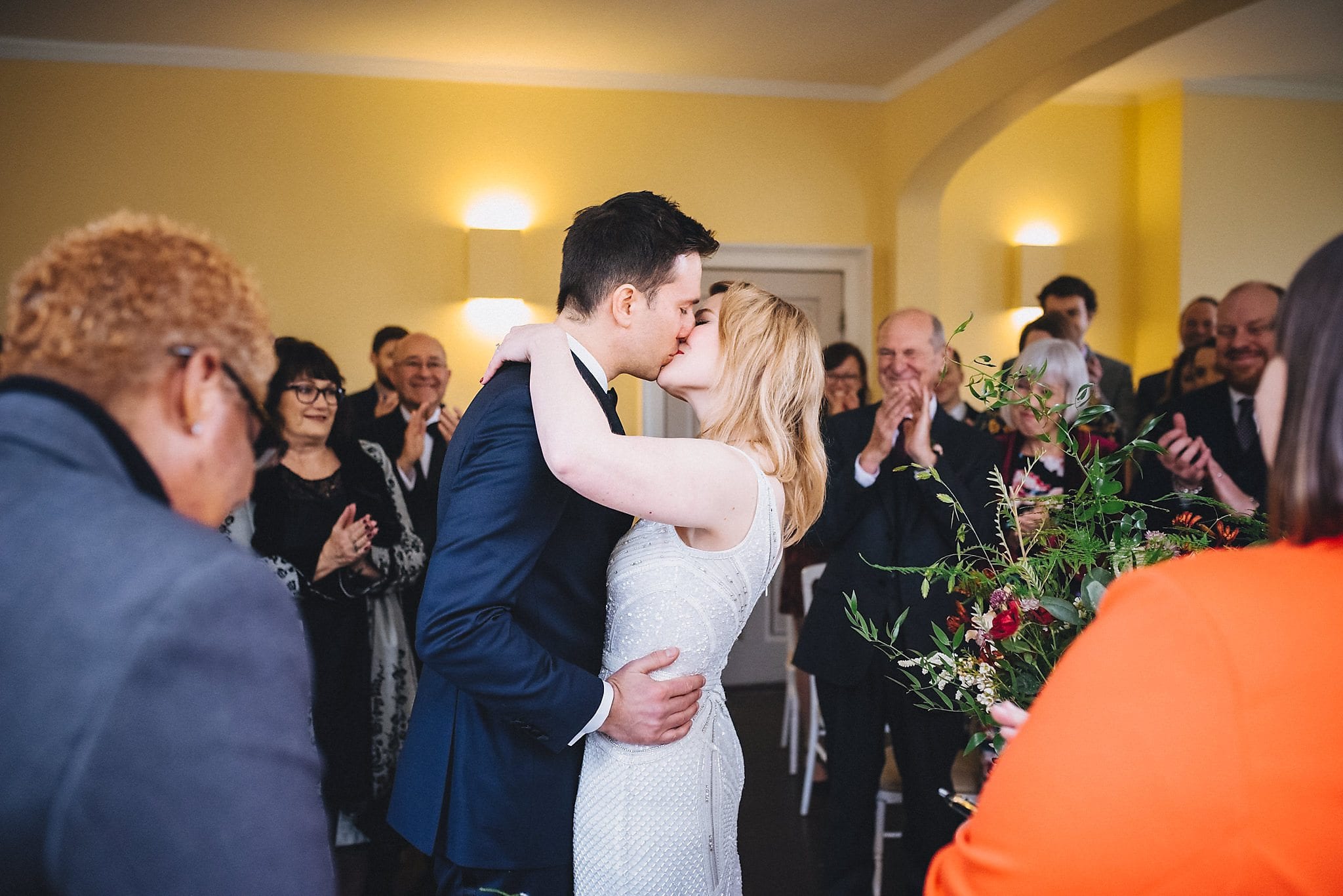 Bride and groom kiss at wedding ceremony in Clissold House