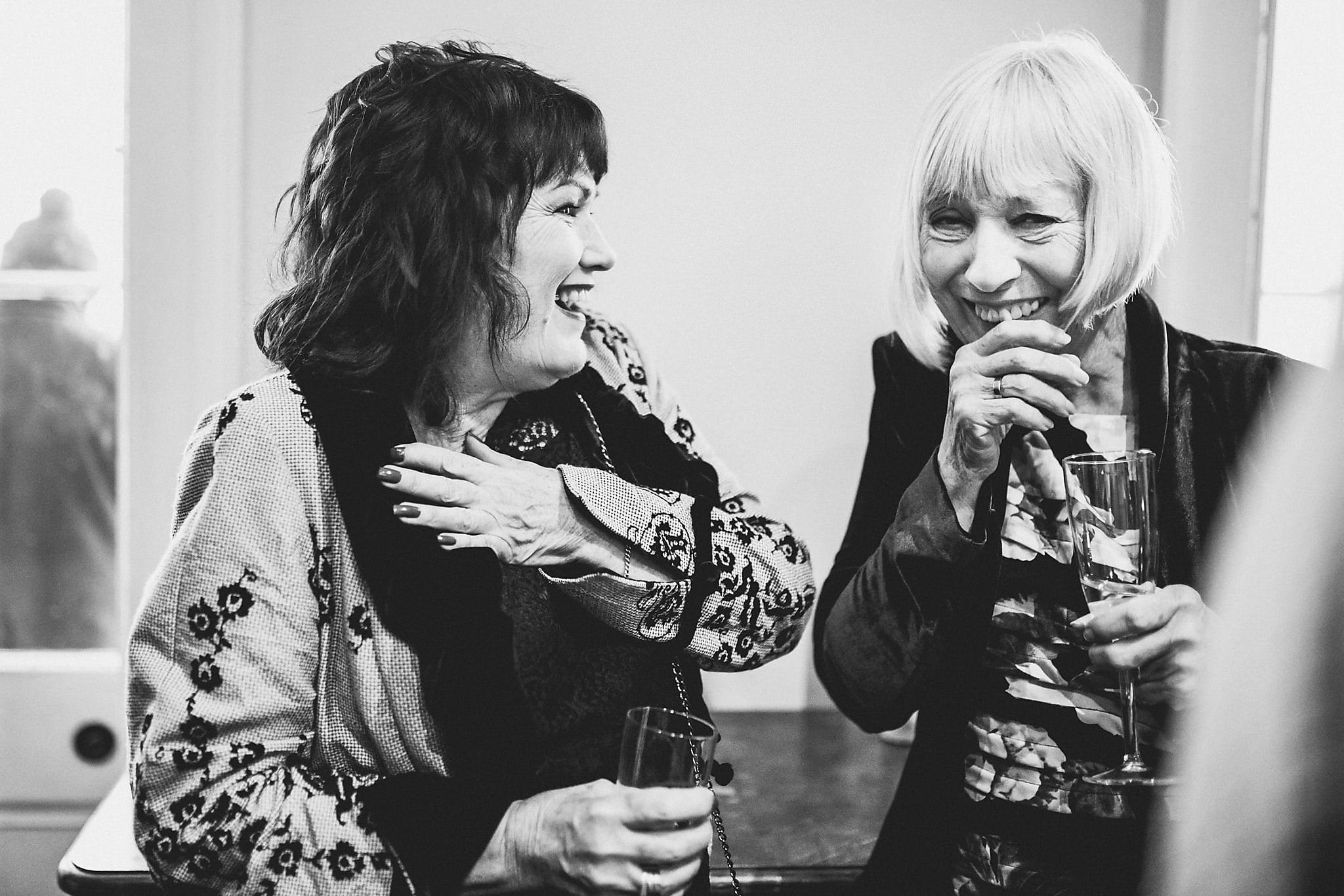 Bride and Groom's mums laughing together at their Clissold House wedding