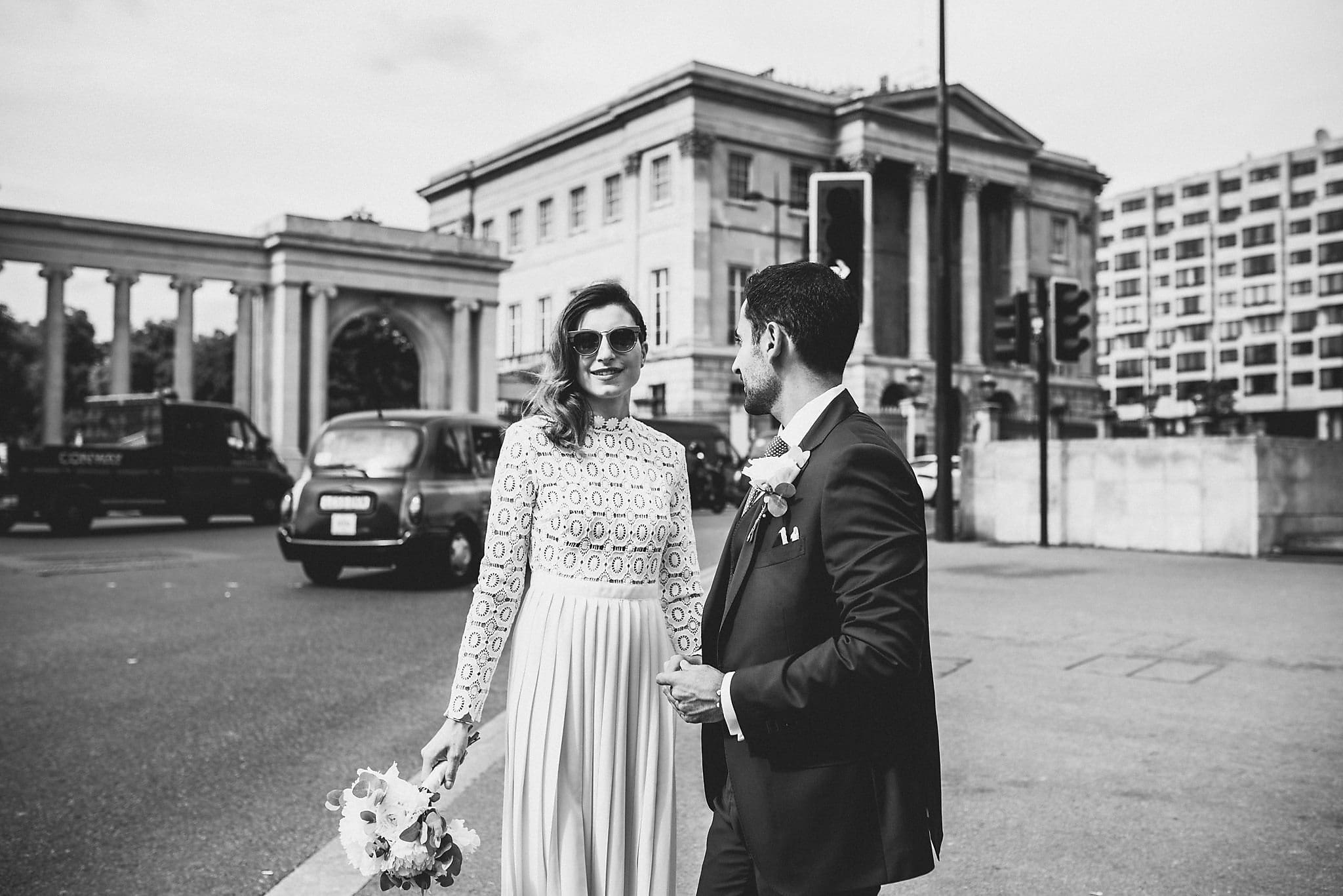 Bride and groom smile at Marble arch and Hyde Park Corner