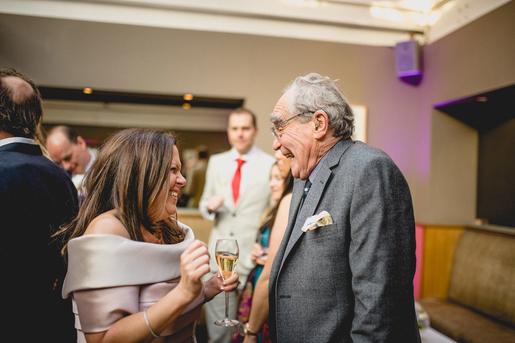 Bride laughing with elderly guest at wedding