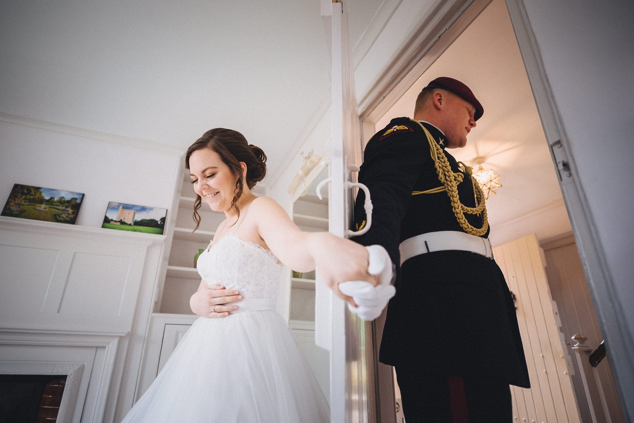 Bride and groom hold hands either side of door and say a prayer