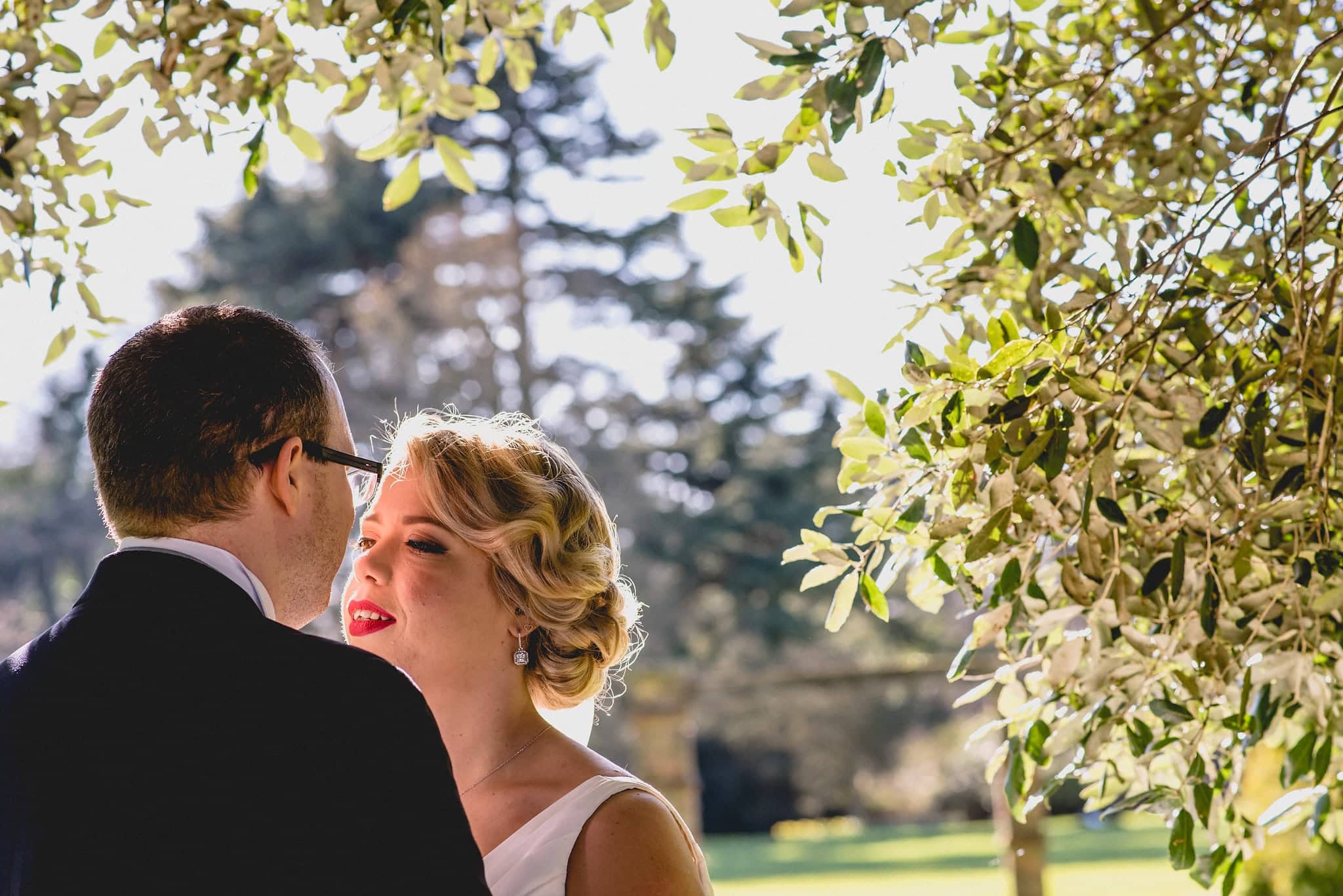 Bride and groom kiss under trees at Shendish Manor