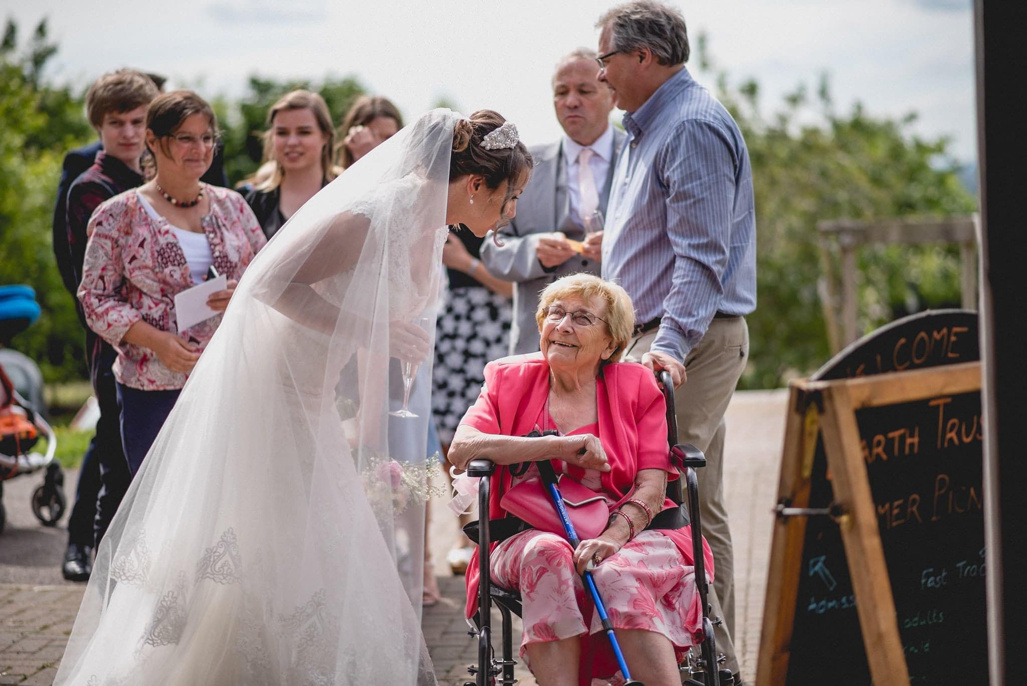 Bride speaks to older guest in wheelchair