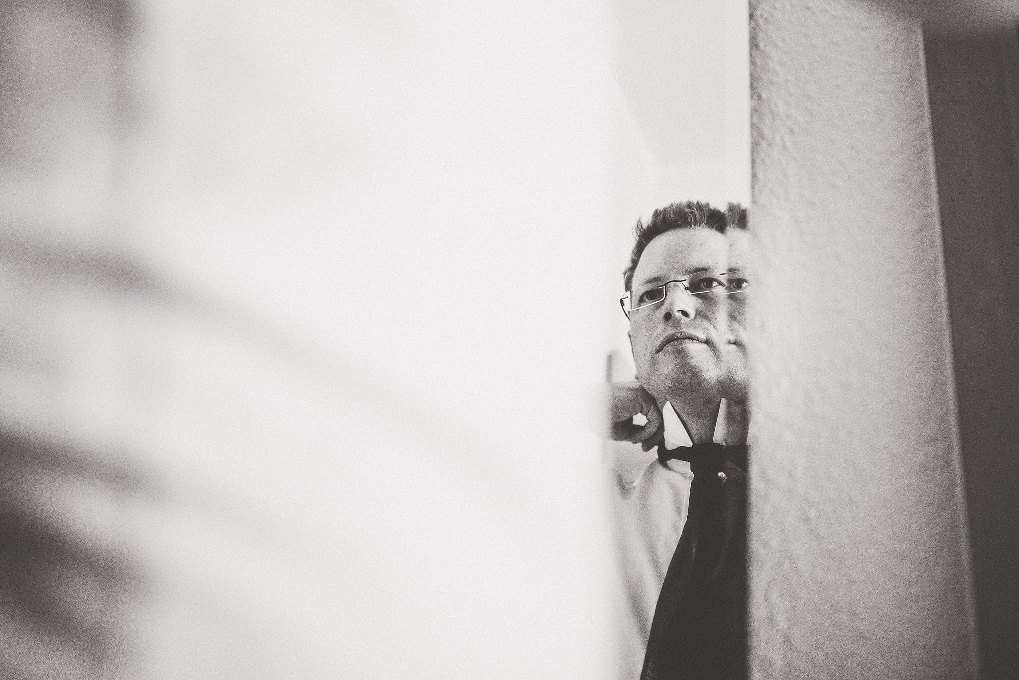 Groom getting ready looking at himself in the mirror