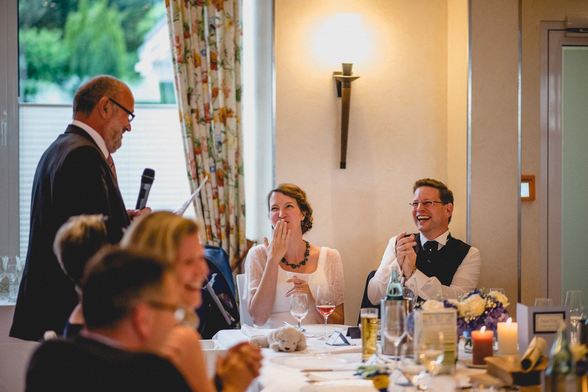 Bride and Groom laughing at the father of the bride's speech