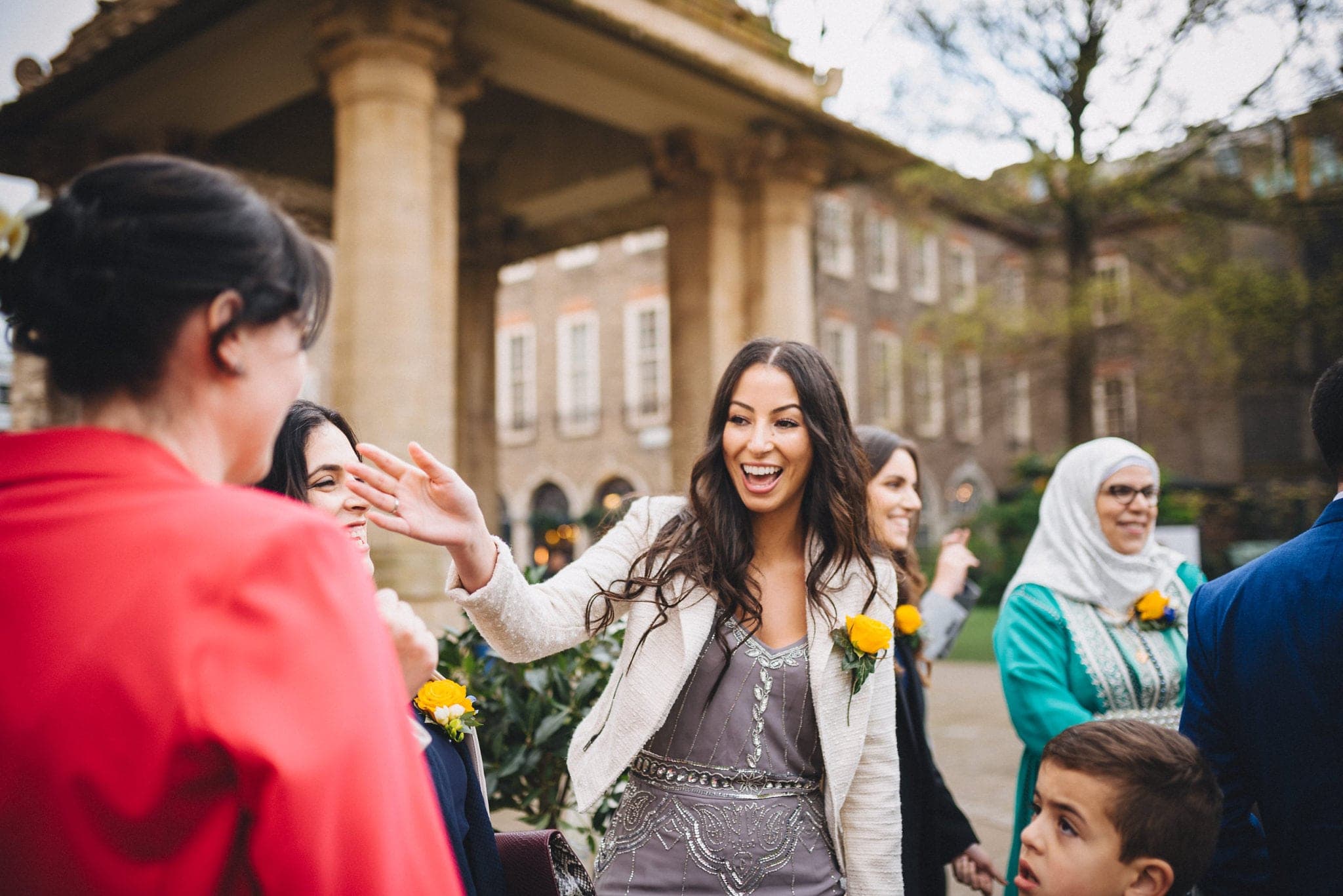 Guests wear bright yellow roses on their lapels outside Brighton Pavilion