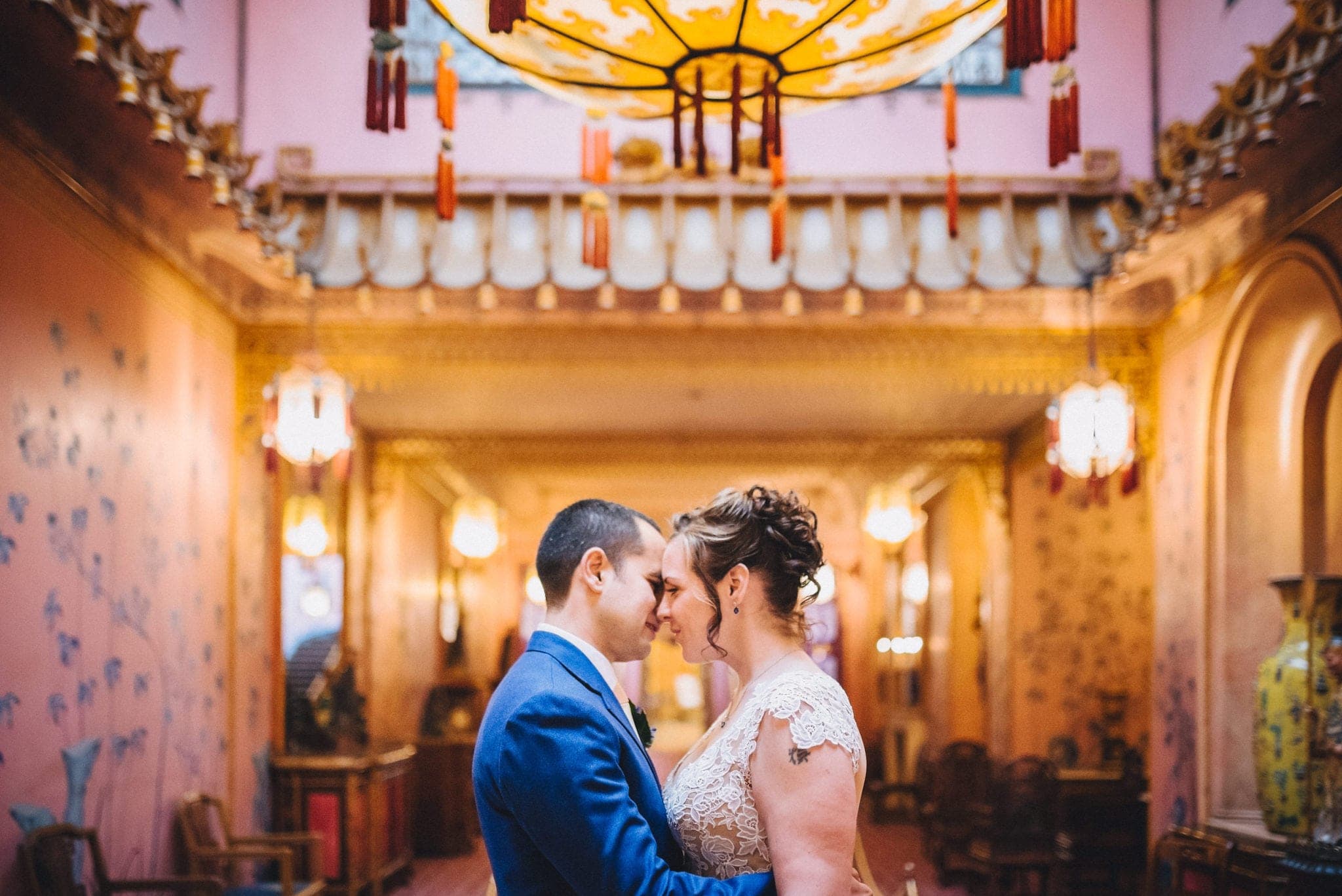 Bride and groom embrace in Brighton Royal Pavilion underneath lantern