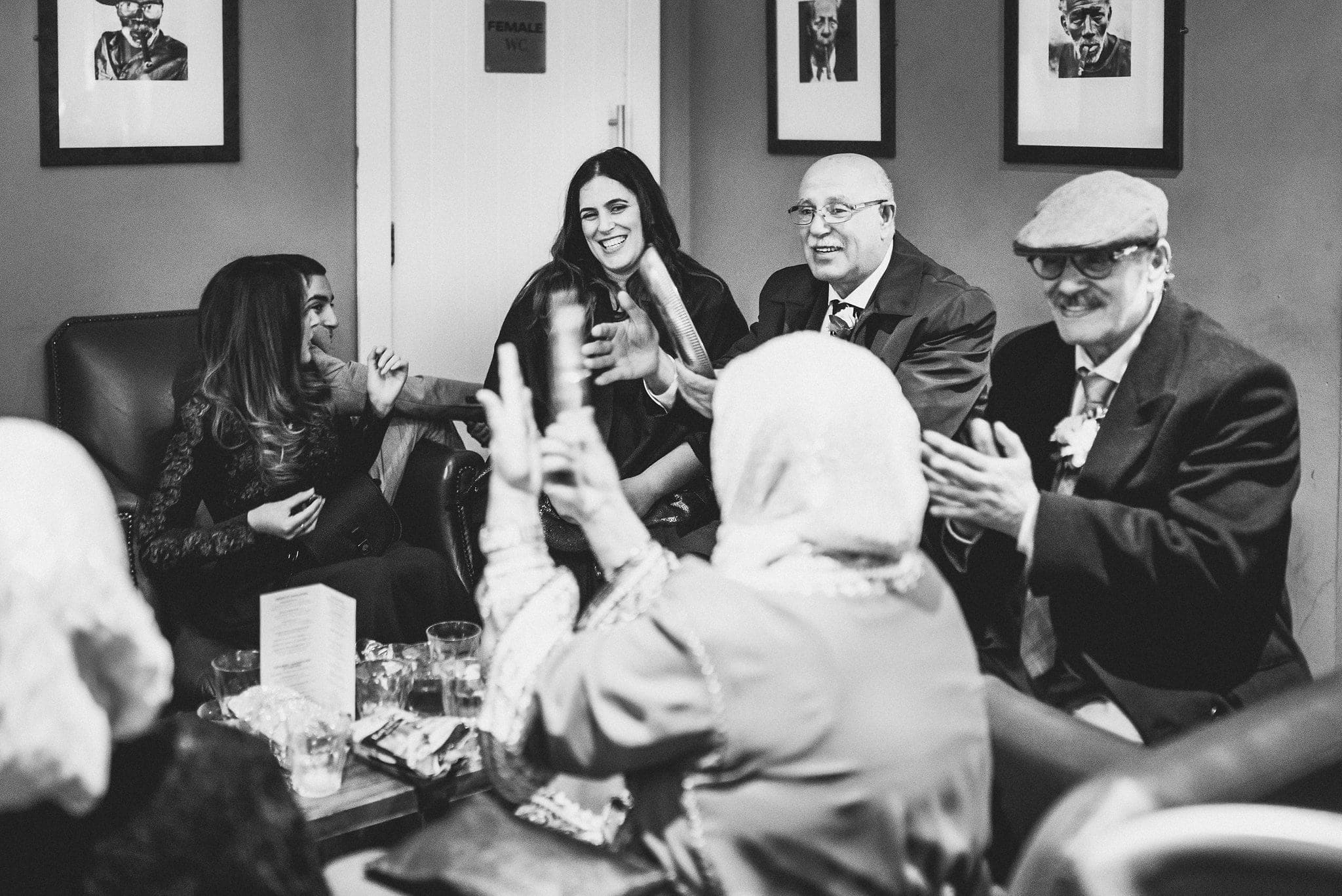 Black and white candid group shot of Moroccan guests at Brighton Royal Pavilion wedding