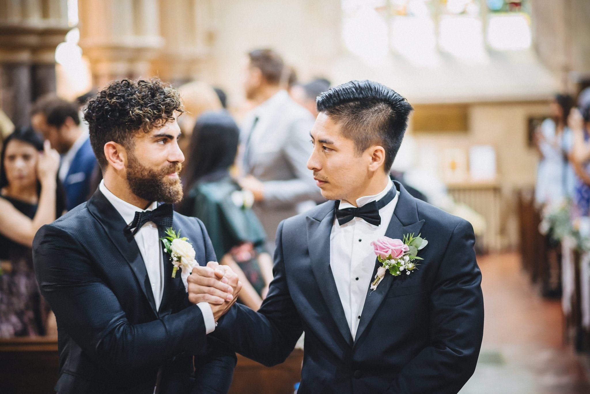 Groom at best man clasp hands while waiting for bride at church