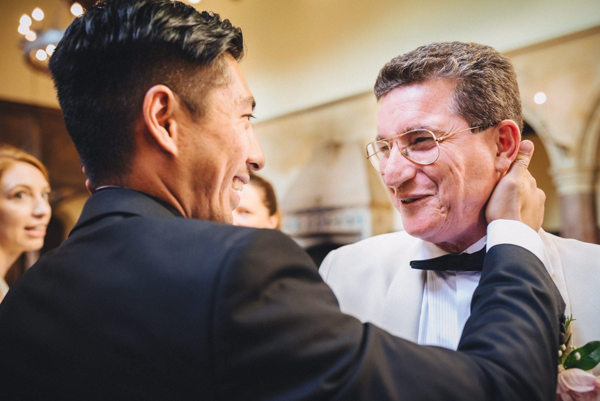 Groom and father of the bride share a tender moment