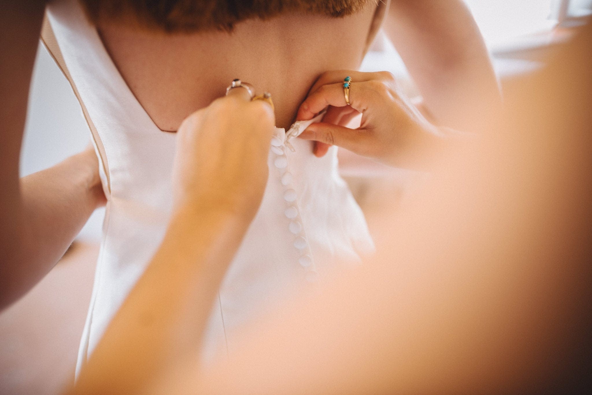 Close up of the bride's dress being done up