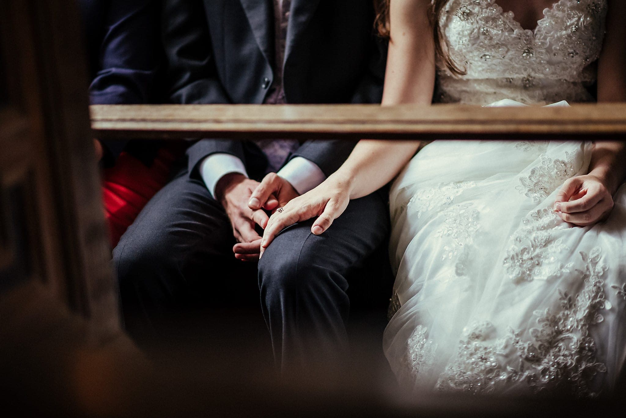 Bride holding groom's hand under the pews at Dorney Court Church