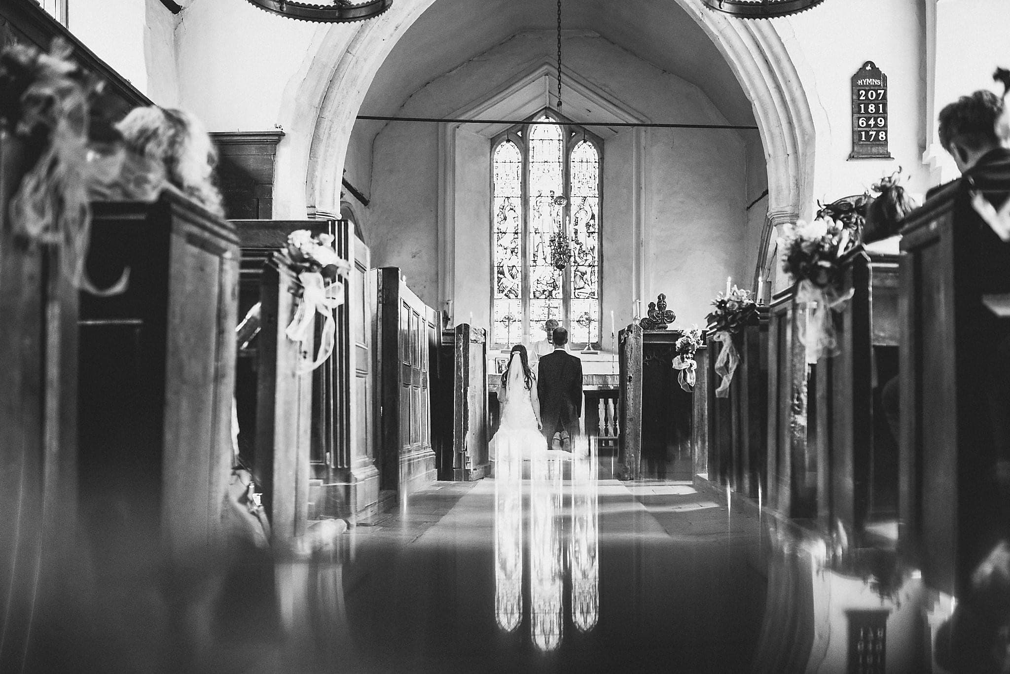 Bride and Groom kneeling at Dorney Court Church