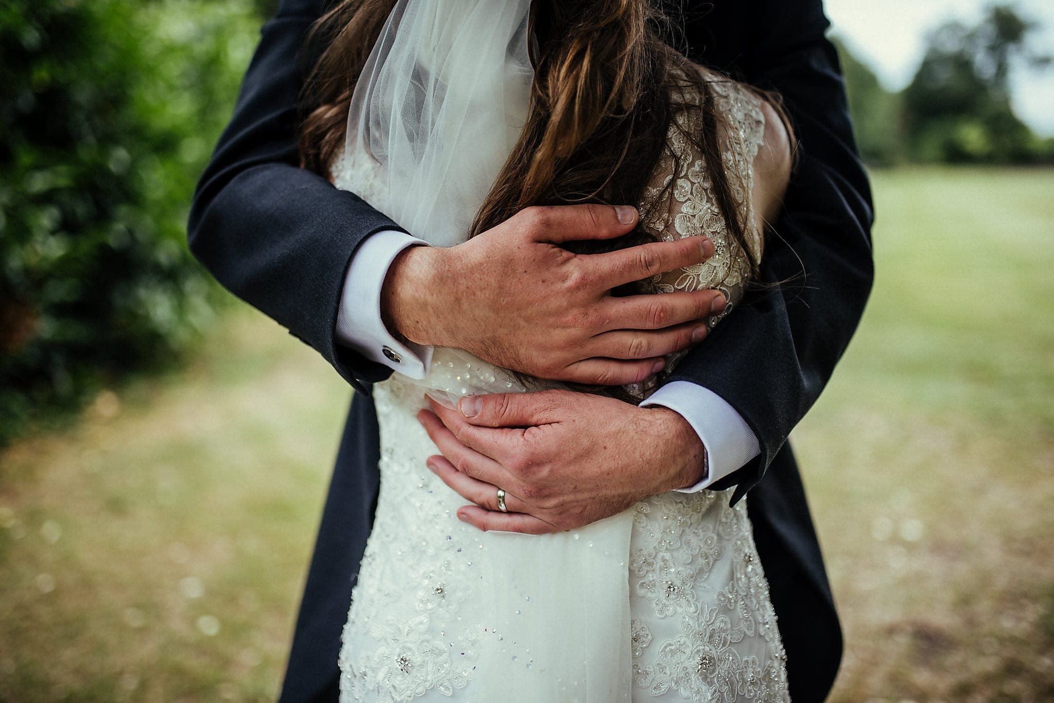 Groom hugging his bride close at their Lovely and Lively Dorney Court Tipi Wedding