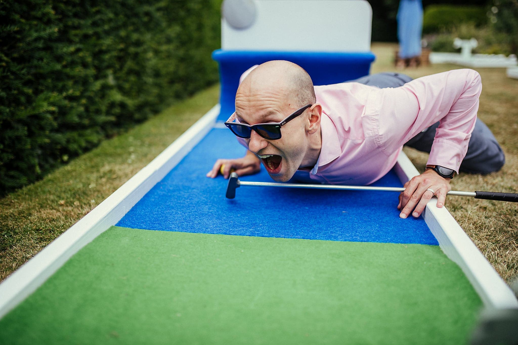 Male wedding guest gets competitive during mini golf tournament at Dorney Court tipi wedding