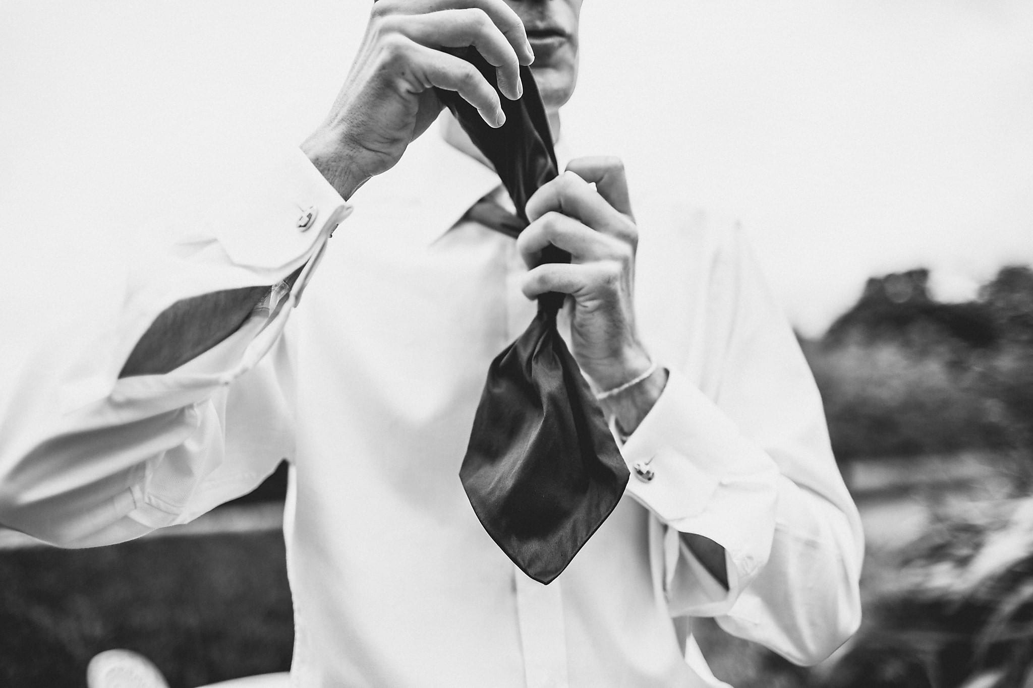 Groom tying his tie