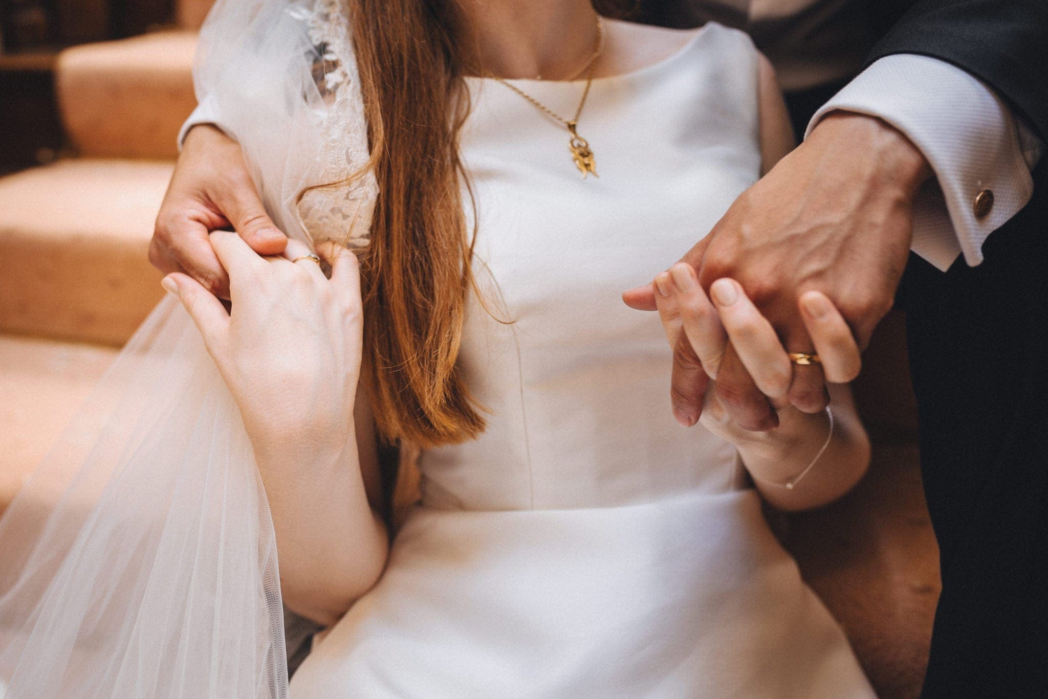 Closeup of the bride and groom holding hands