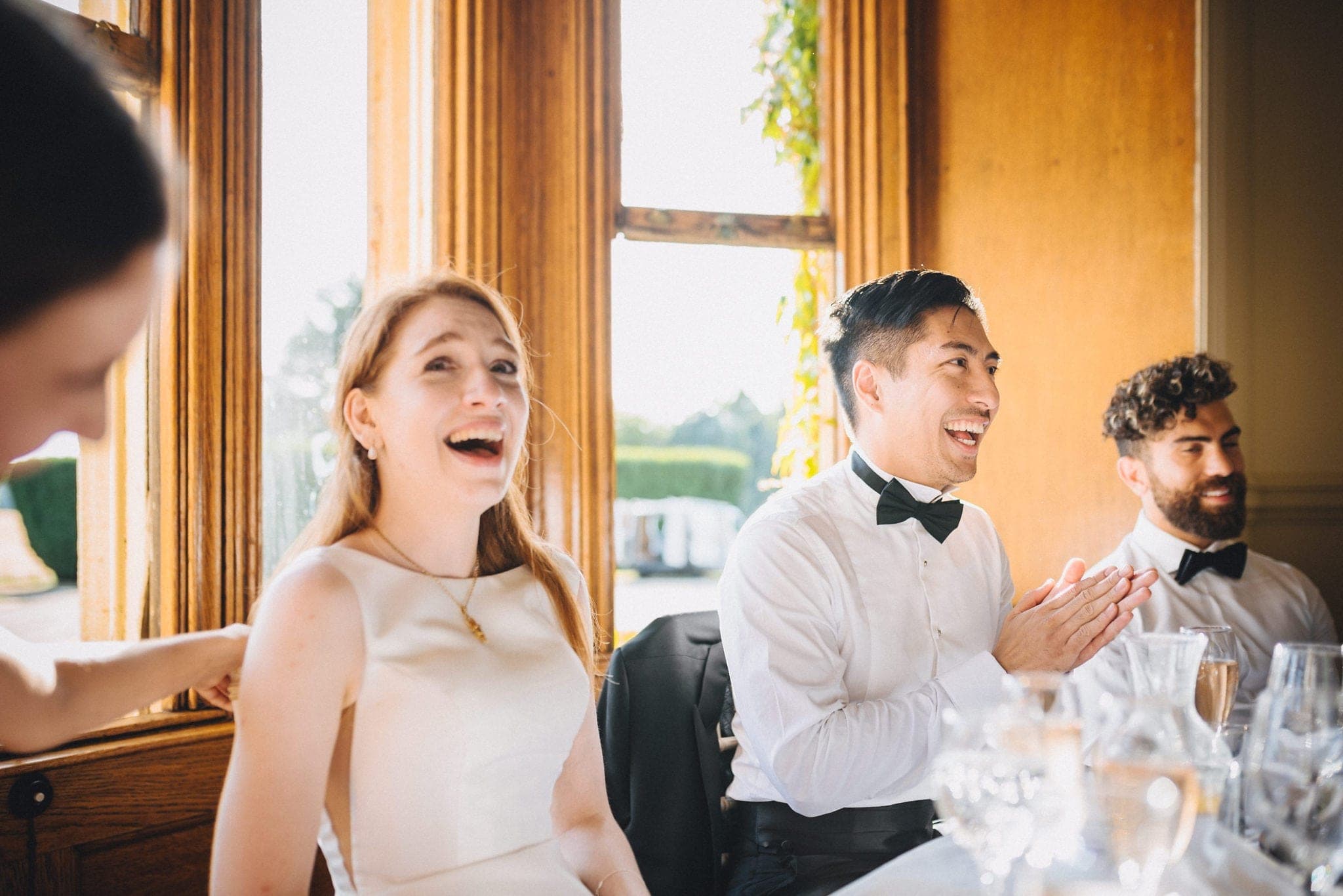 Bride and groom laughing at wedding speeches