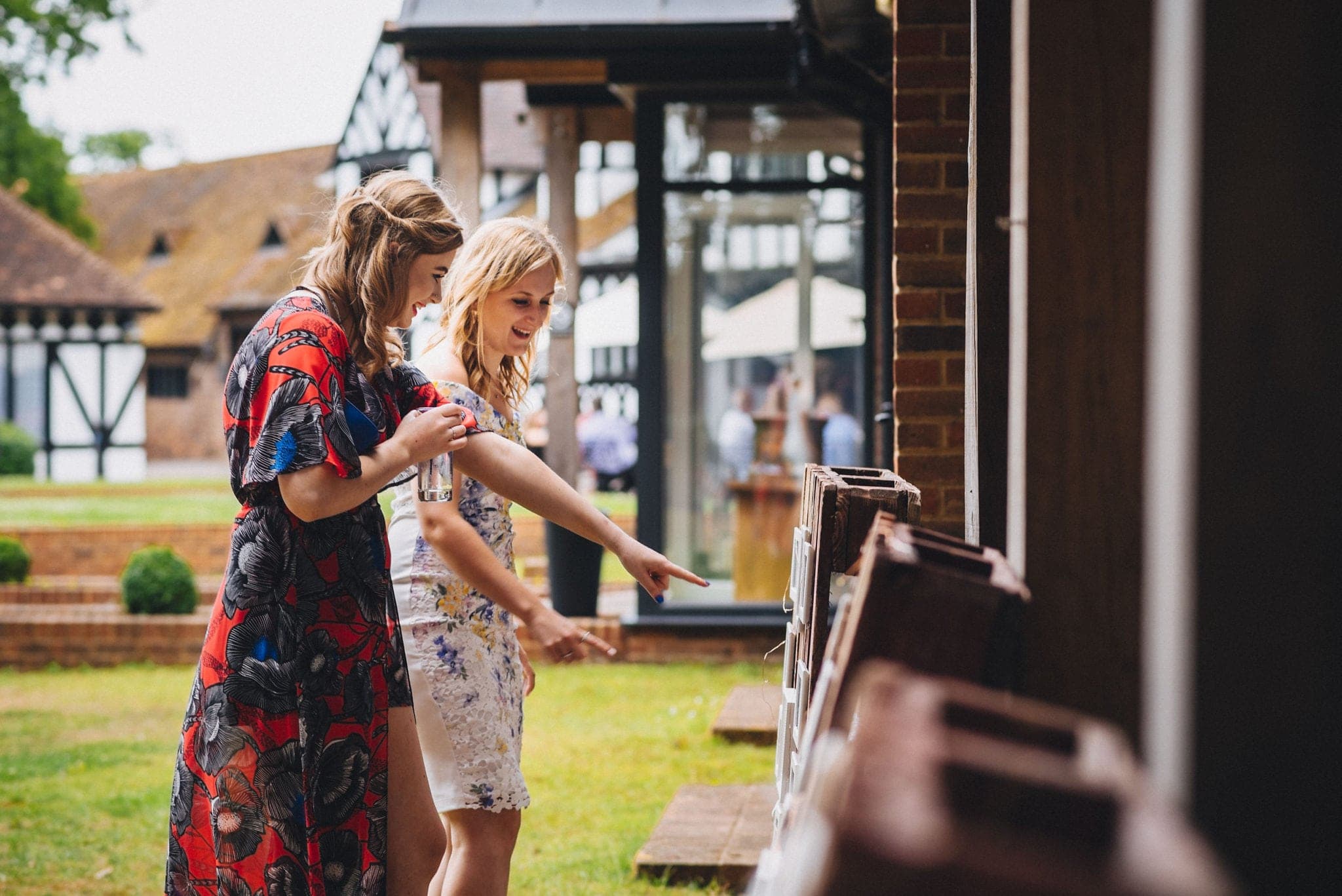 Guests point at photos of bride and groom set up outside Hever Hotel