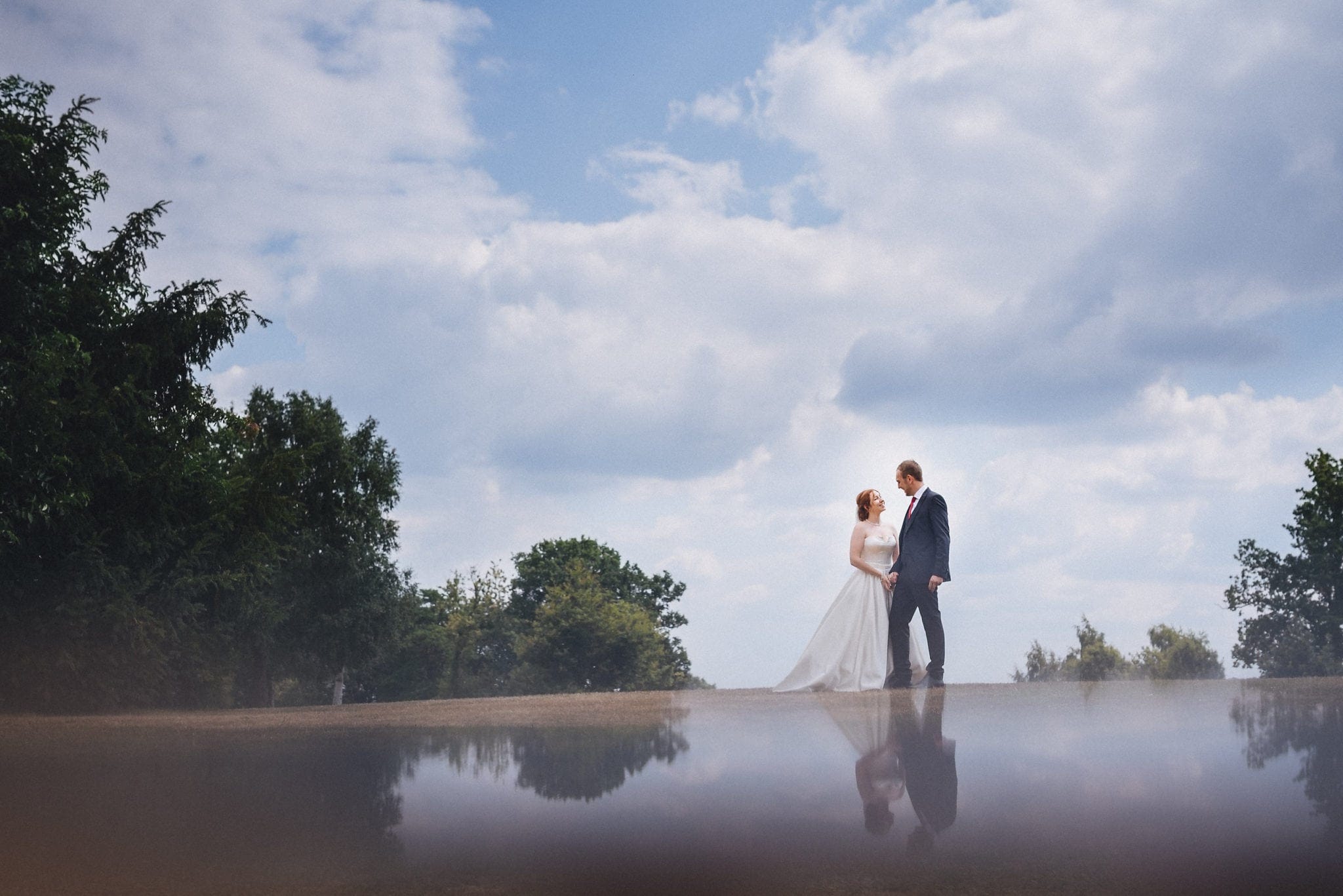 Bride and groom hold hands at their joyful intimate Hever Hotel Wedding