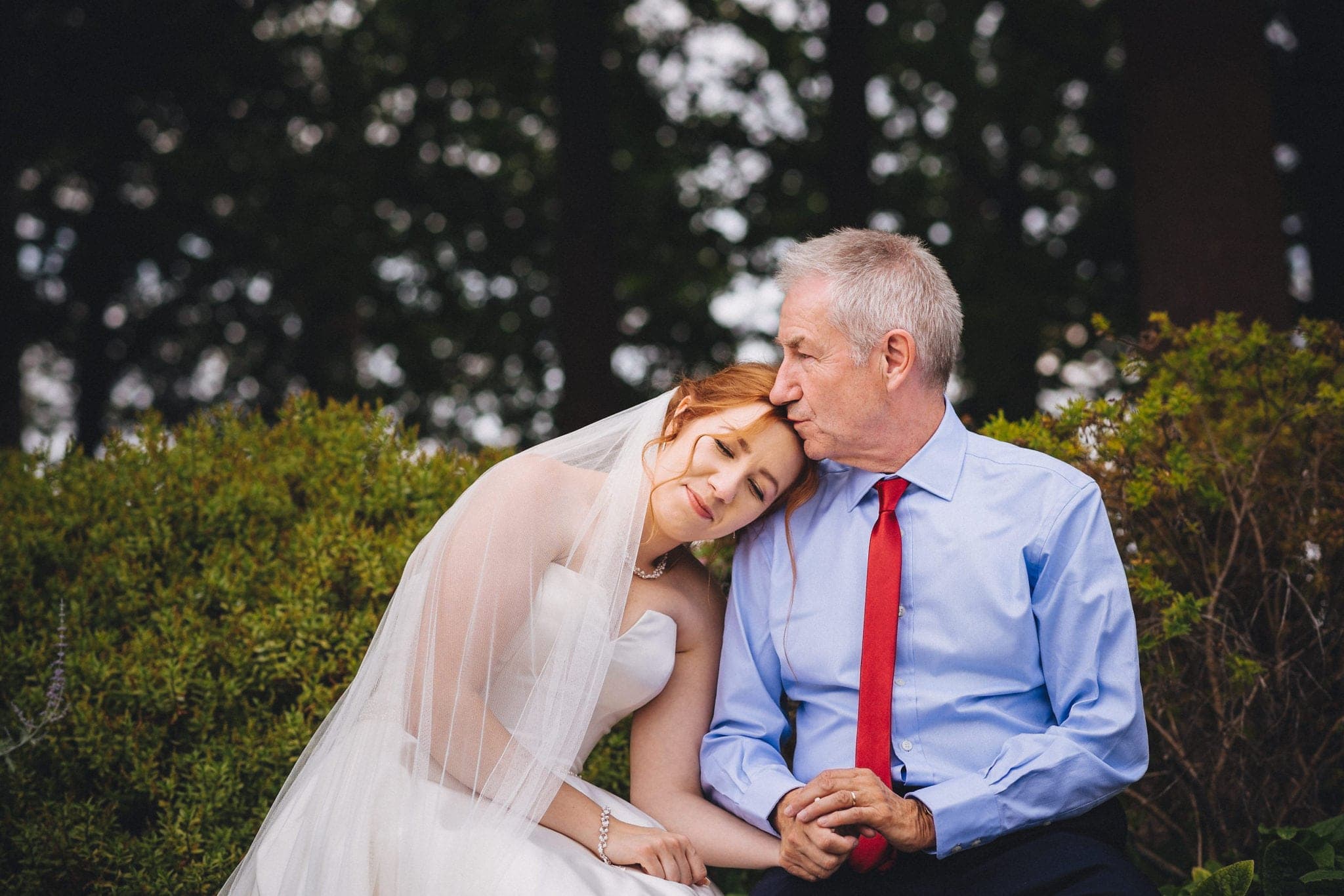 Bride leans her head on her father's shoulder