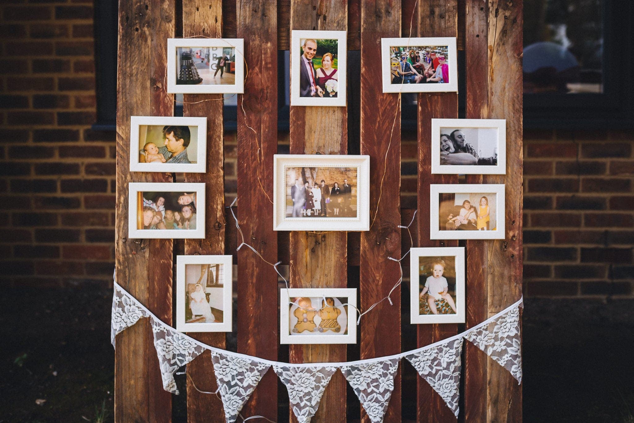 Framed photos of the bridal couple on a palette with fairylights and lace bunting