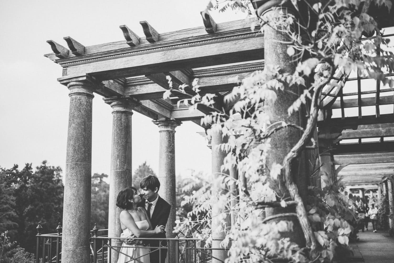 bride and groom lean against the banister at the pergola wedding venue