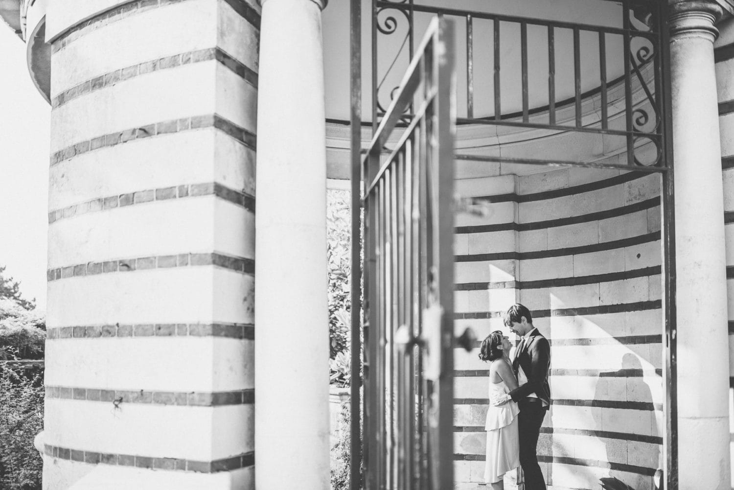 Couple hold hands in the stripy walls at the Hampstead Pergola and Hill Gardens