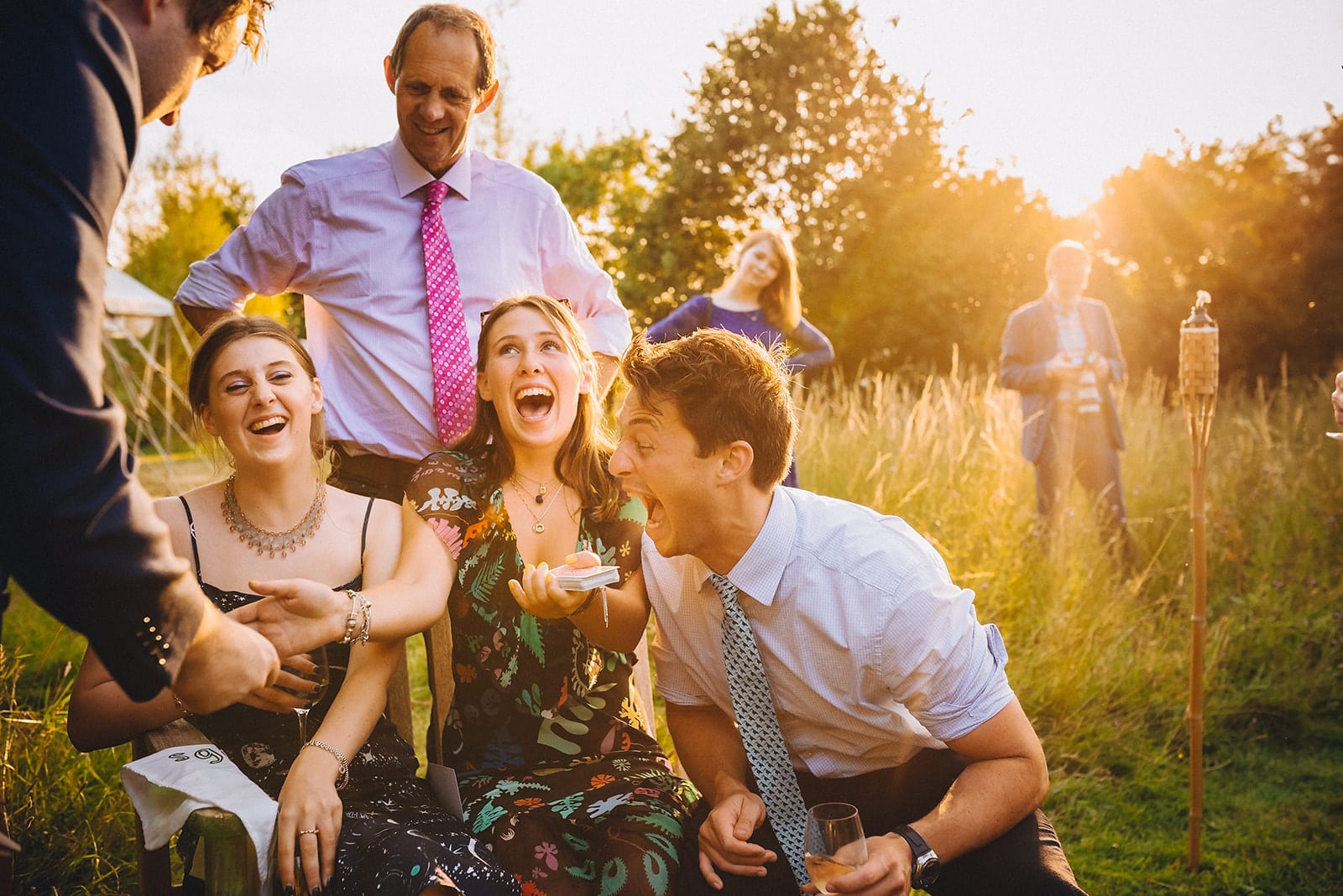 Wedding guests laughing guffawing at a magic trick by the wedding magician