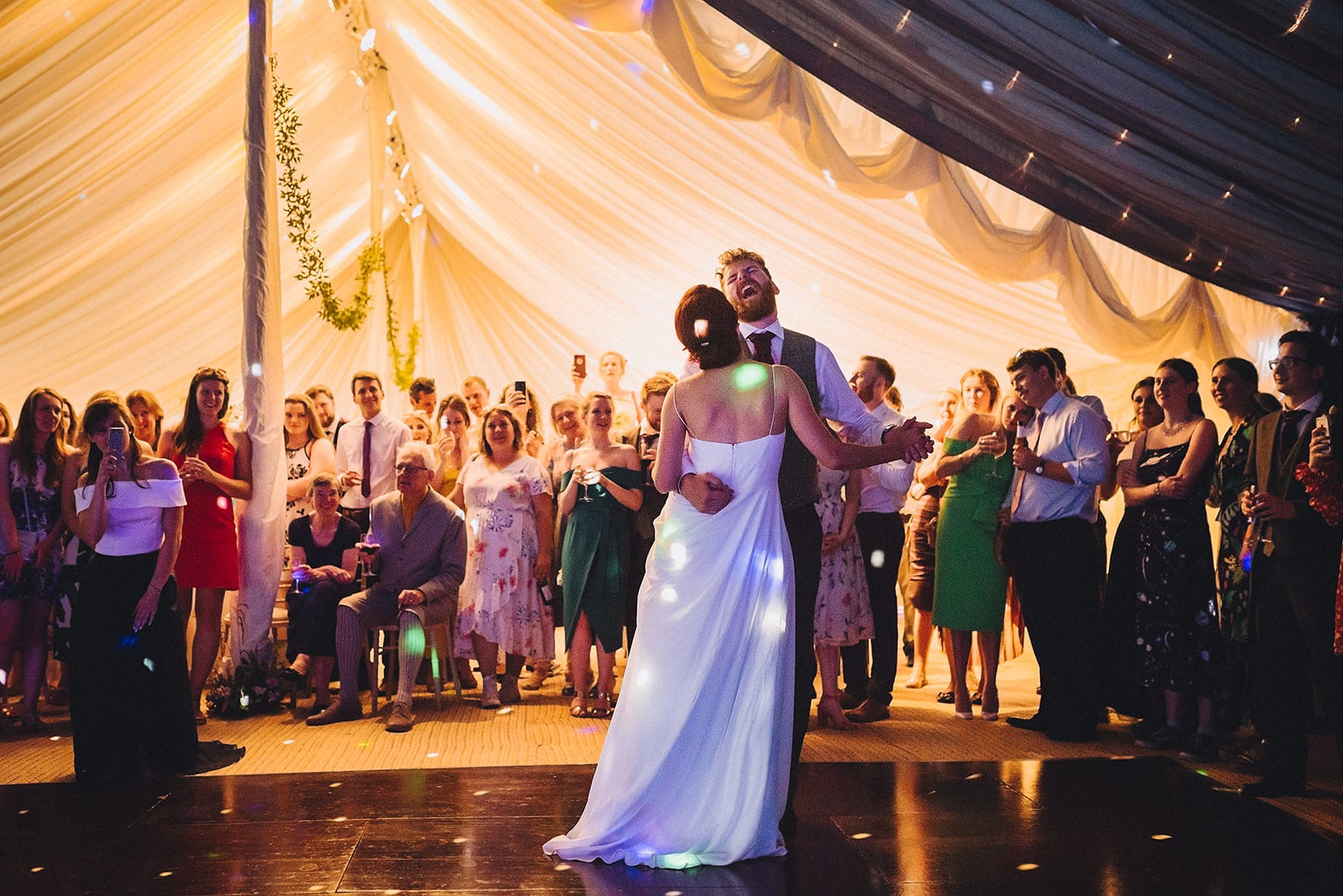 Bride and groom first dance at their joyful cambridge farm marquee wedding