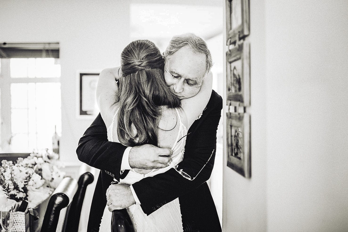 Bride's father hugs her tight before leading for her Fulham wedding ceremony